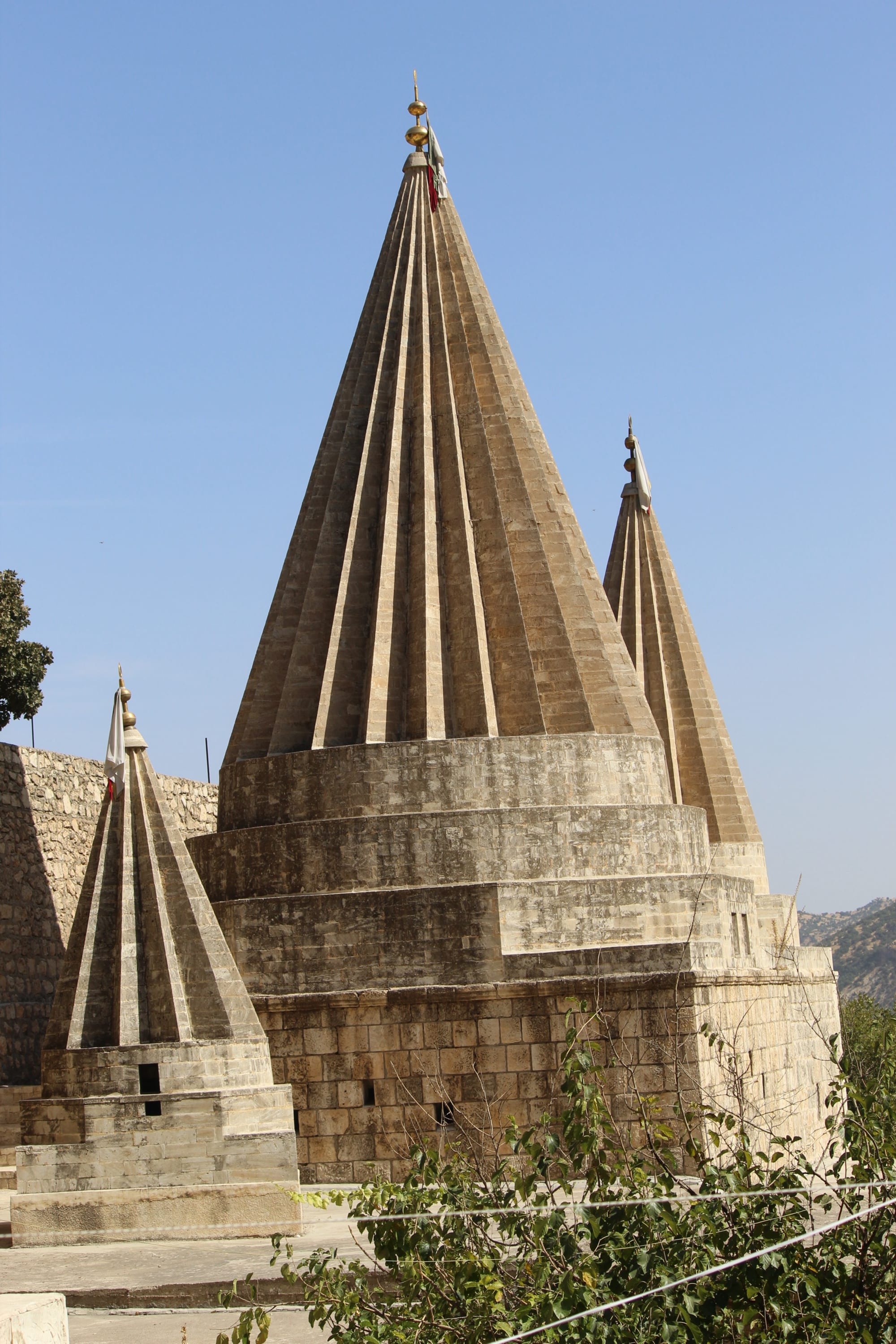 Stone buildings with distinctive fluted conical spires in a green valley