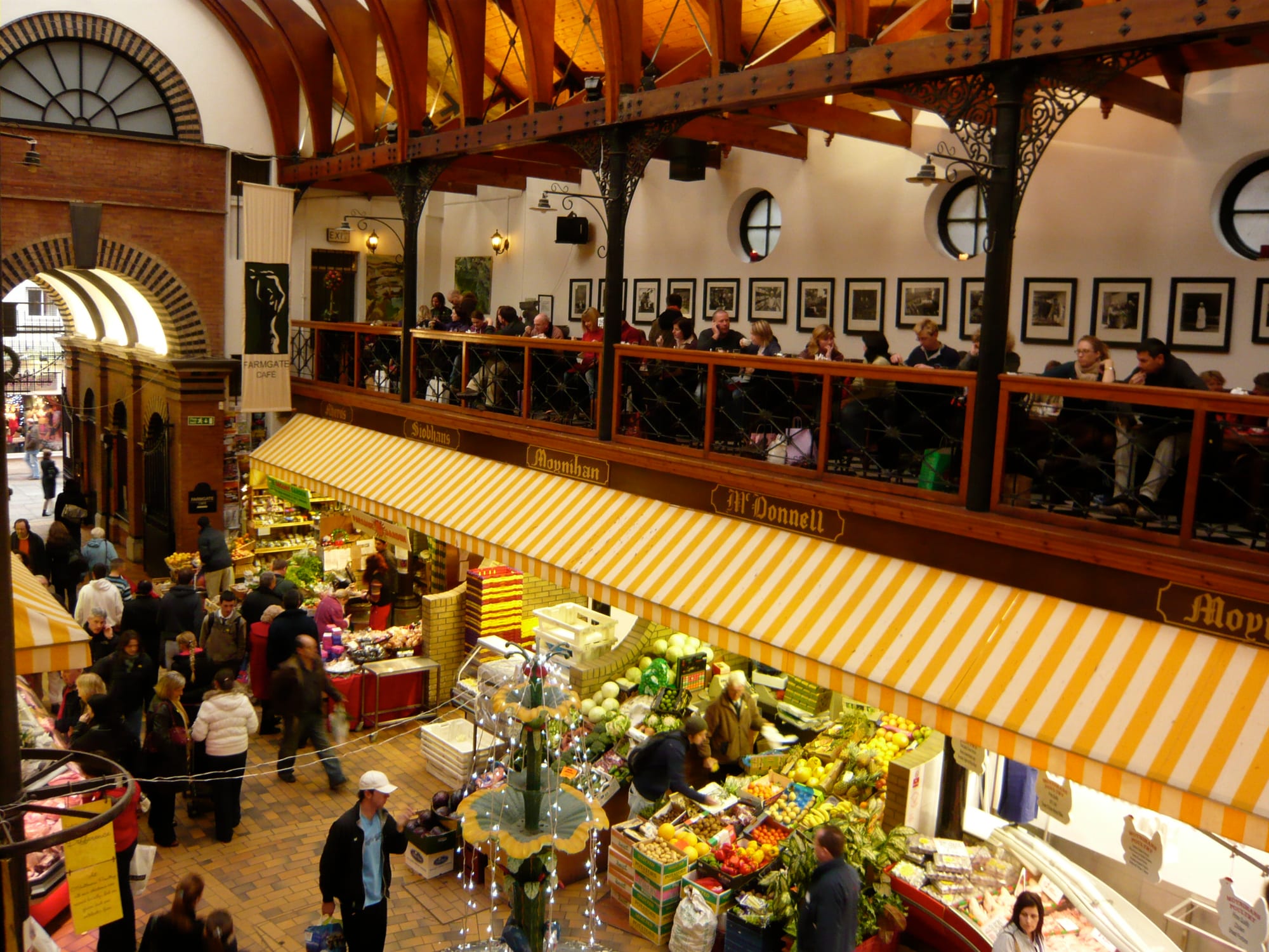 A busy covered food market with stalls of fresh produce