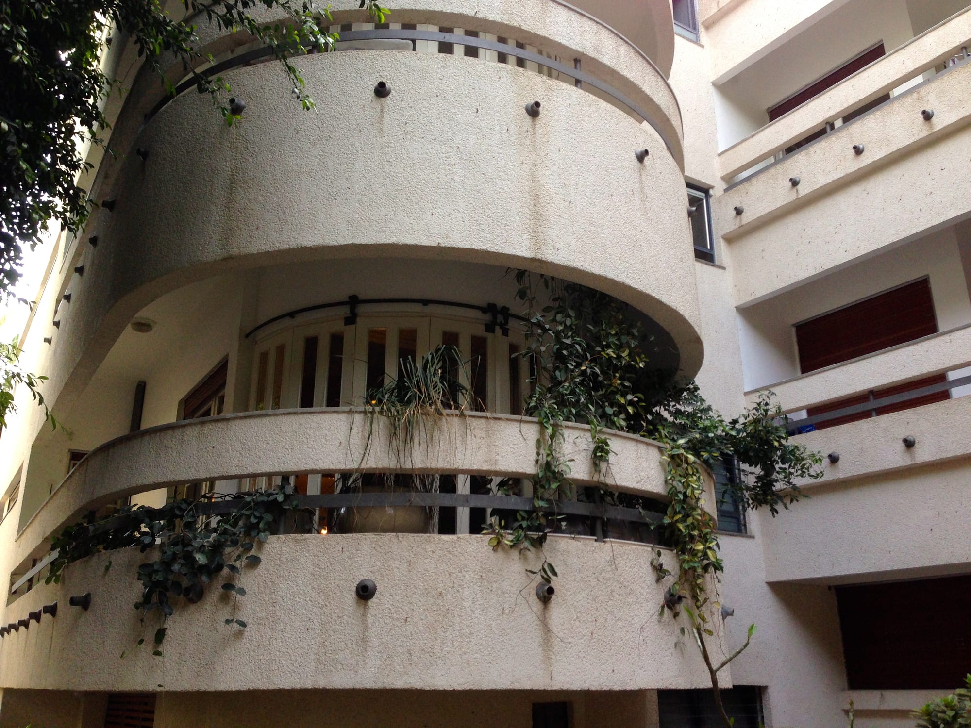 A curved white 1930s apartment building with ribbon windows and rounded balconies