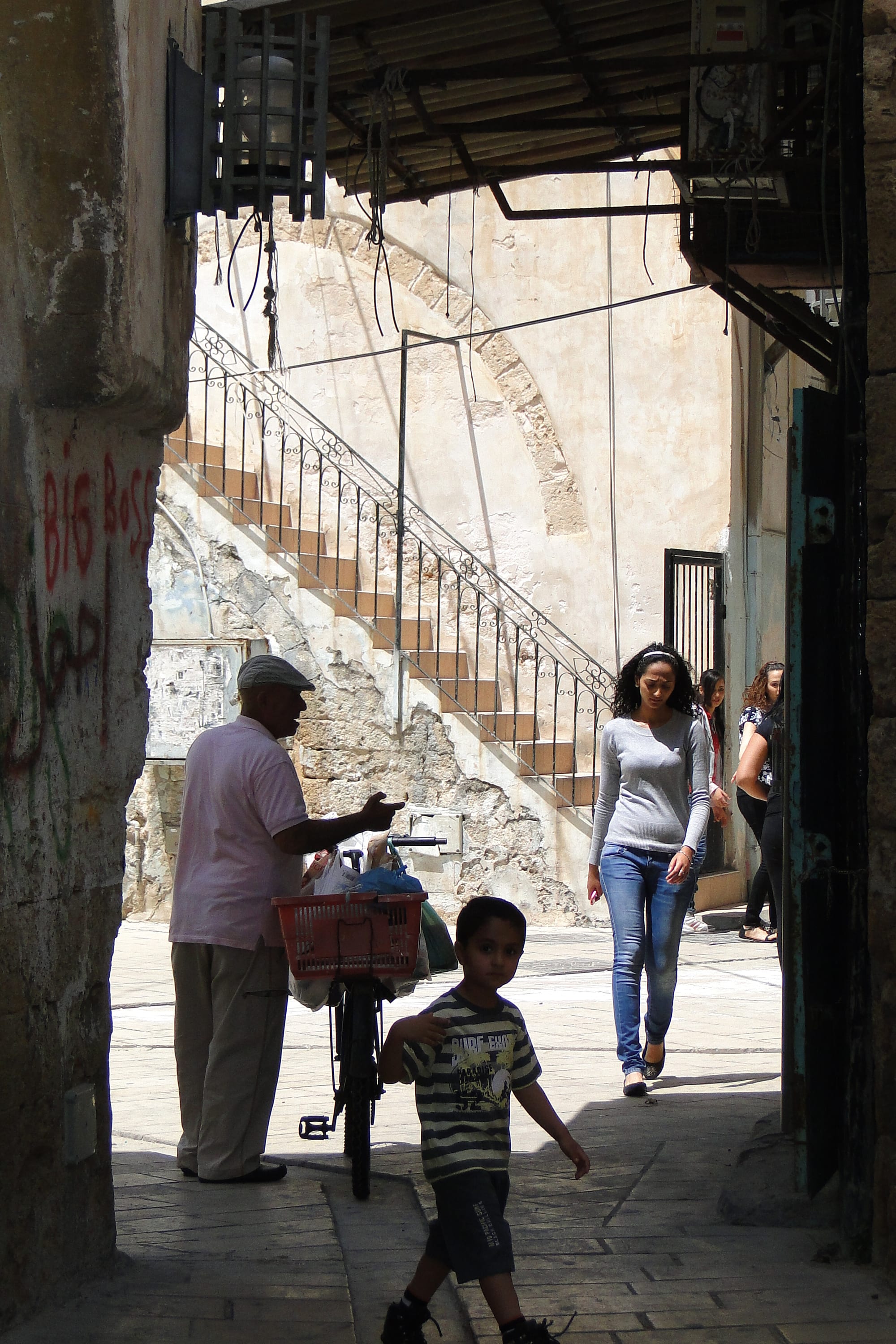 A narrow stone alley of Ottoman-era buildings with arches and shopfronts