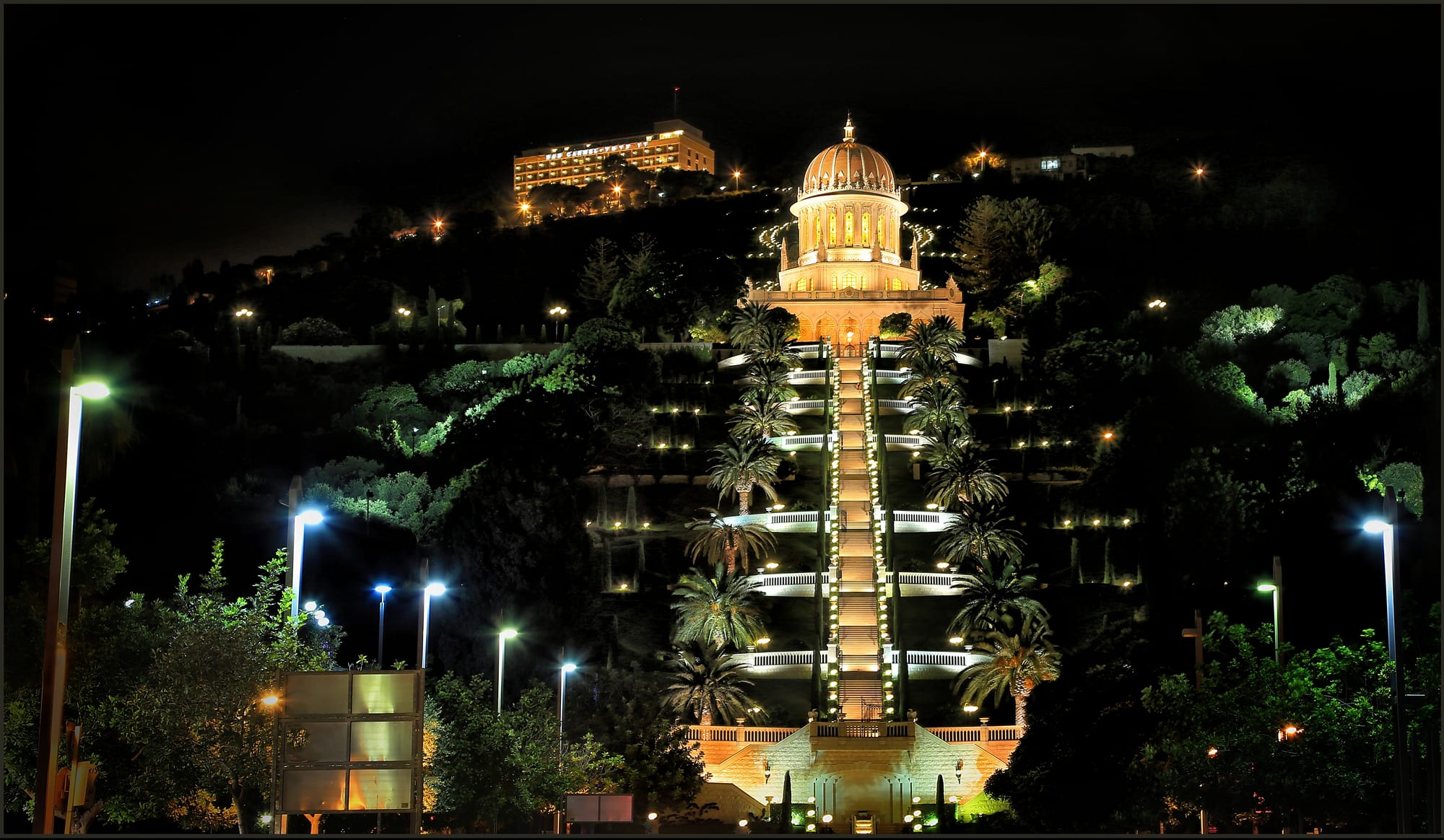 Nineteen manicured garden terraces descending a hillside to a golden-domed shrine and the sea