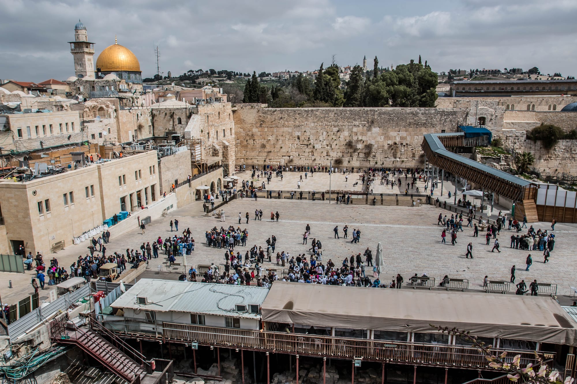 The stone plaza of the Western Wall below the gold Dome of the Rock and the Old City walls of Jerusalem