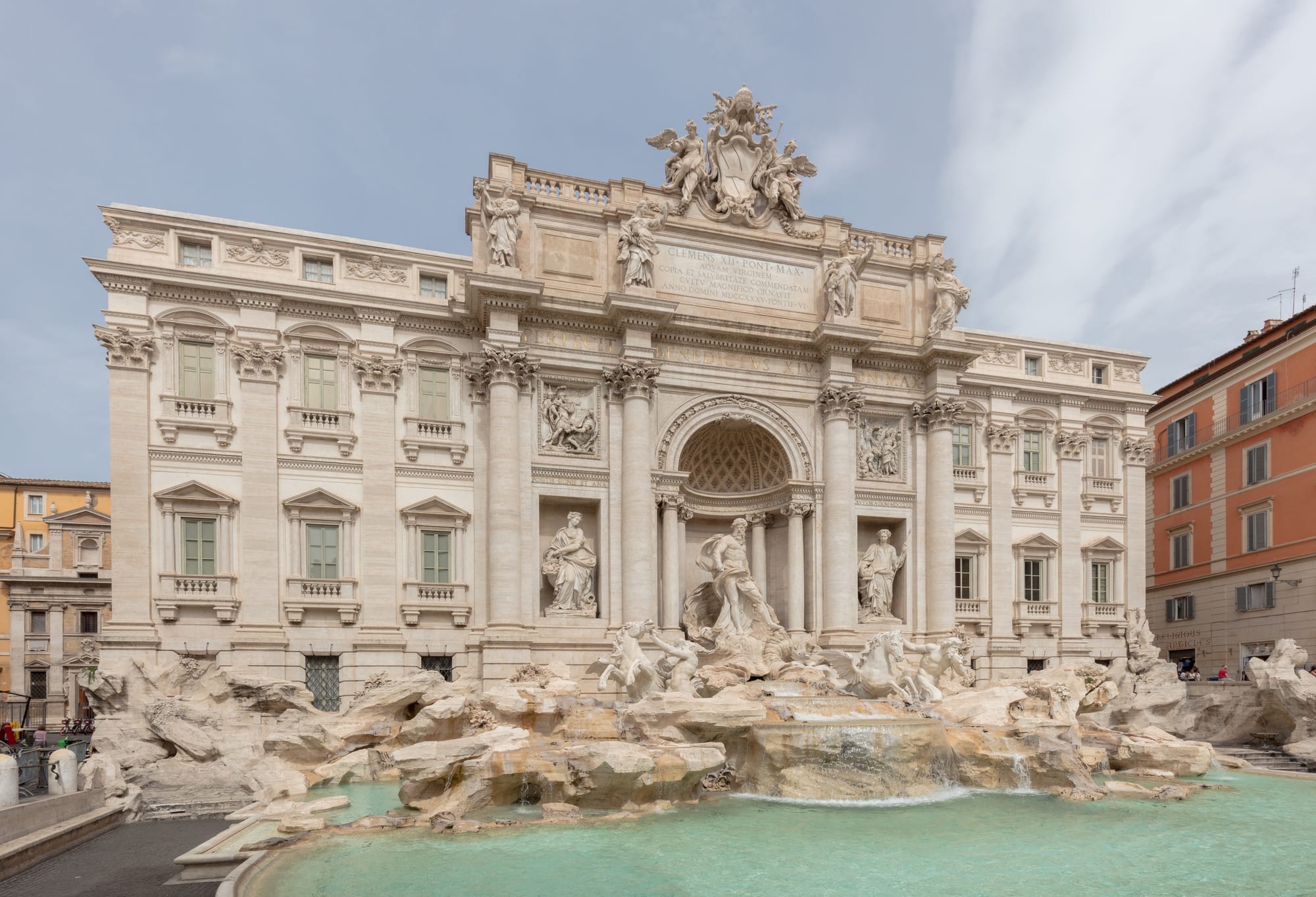 The ornate baroque facade and statues of the Trevi Fountain above its turquoise pool