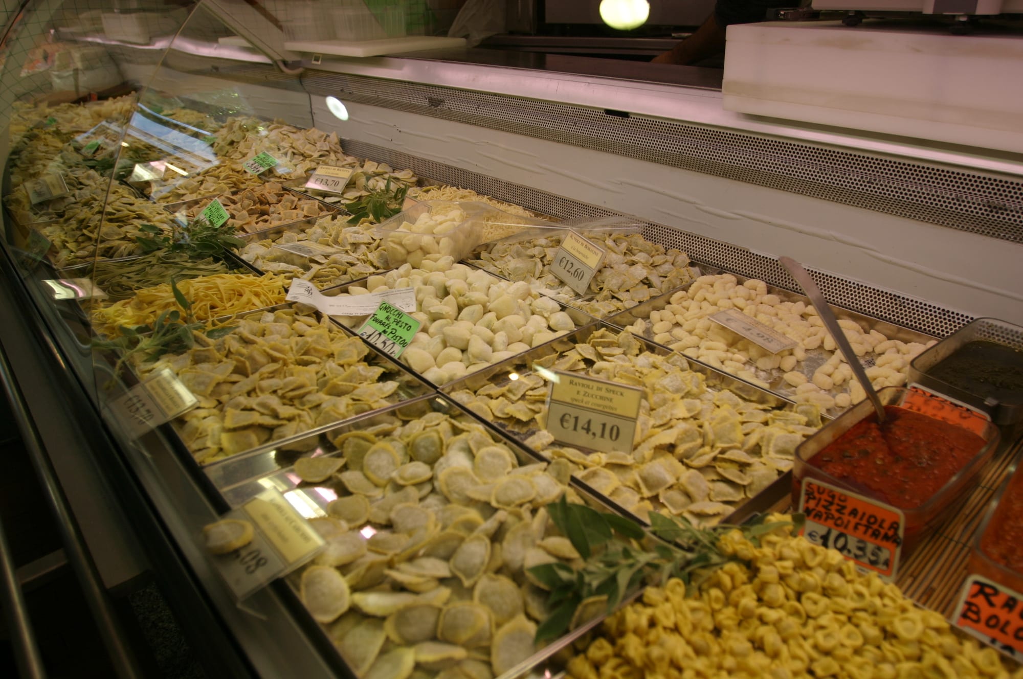 Trays of fresh handmade pasta on display at a market stall