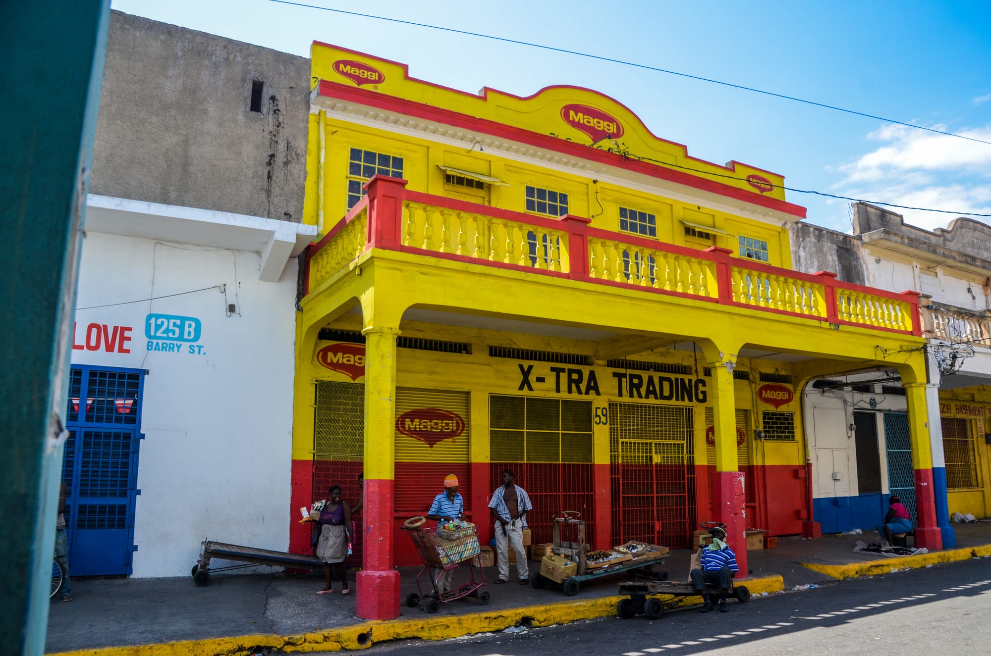 A brightly painted wooden building with a mural on a downtown street