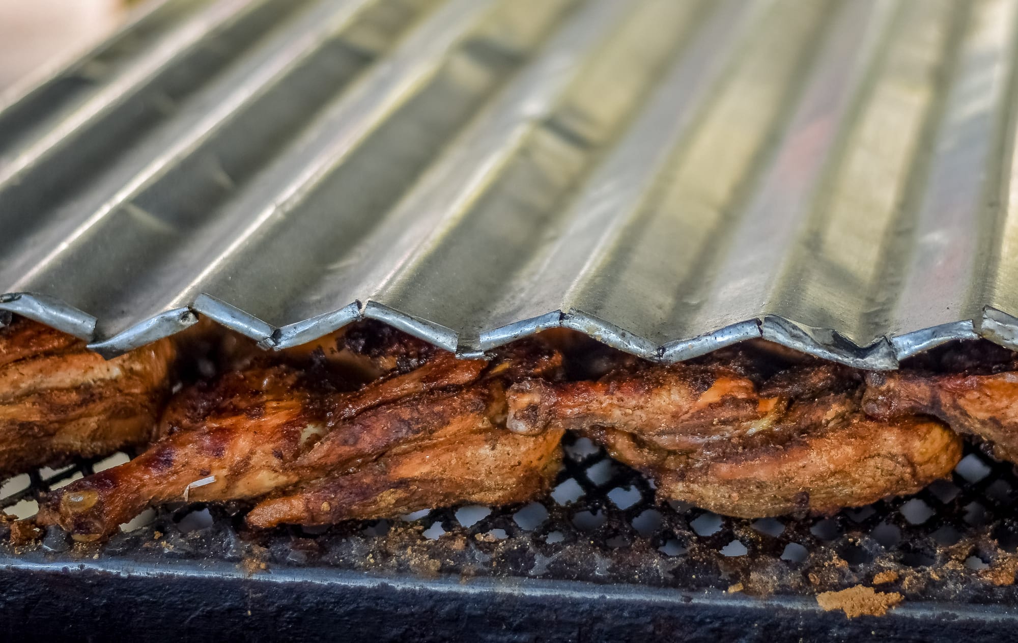 Pieces of grilled chicken with a dark, charred spiced crust