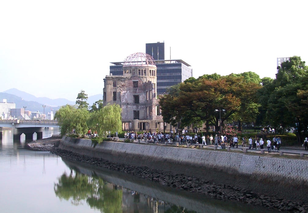 The skeletal ruin of a domed brick building preserved beside a river