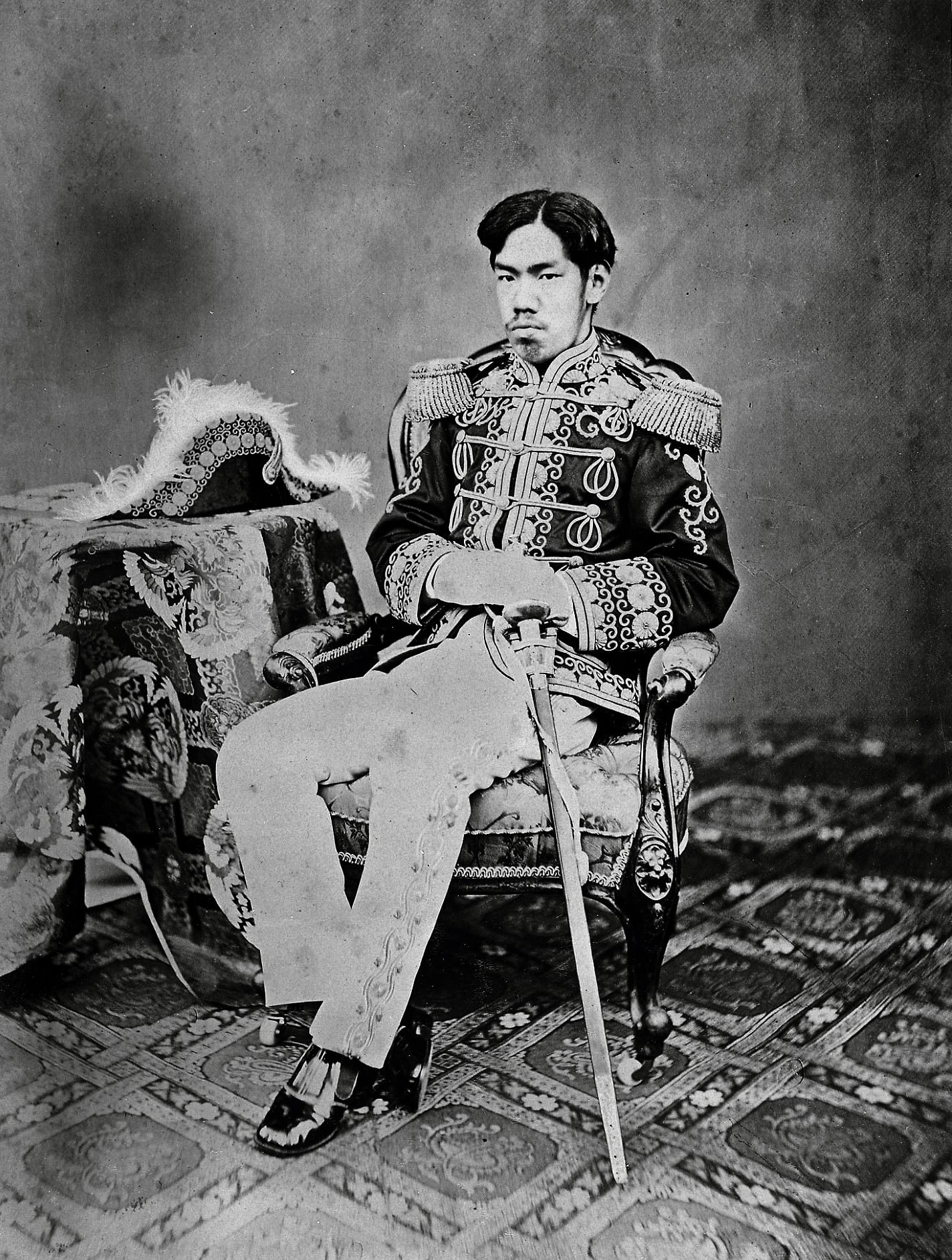 A formal 1870s portrait photograph of the young Emperor Meiji in Western military dress