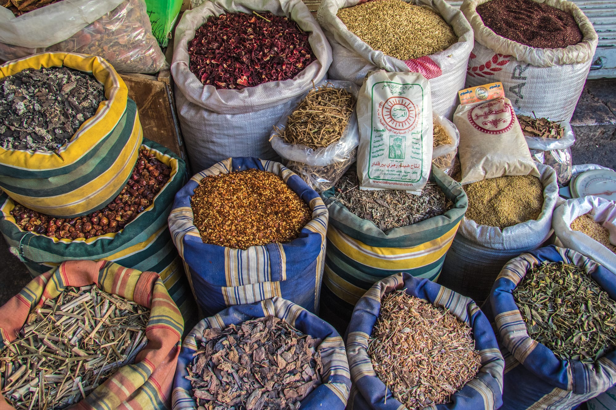 Sacks and bins of colourful ground and whole spices at a market
