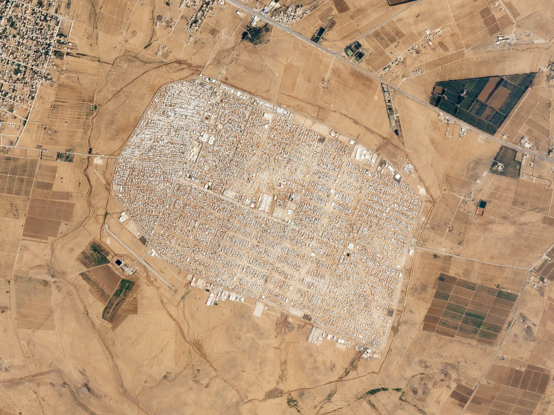 An aerial view of the vast grid of shelters and tents of the Zaatari refugee camp in the desert