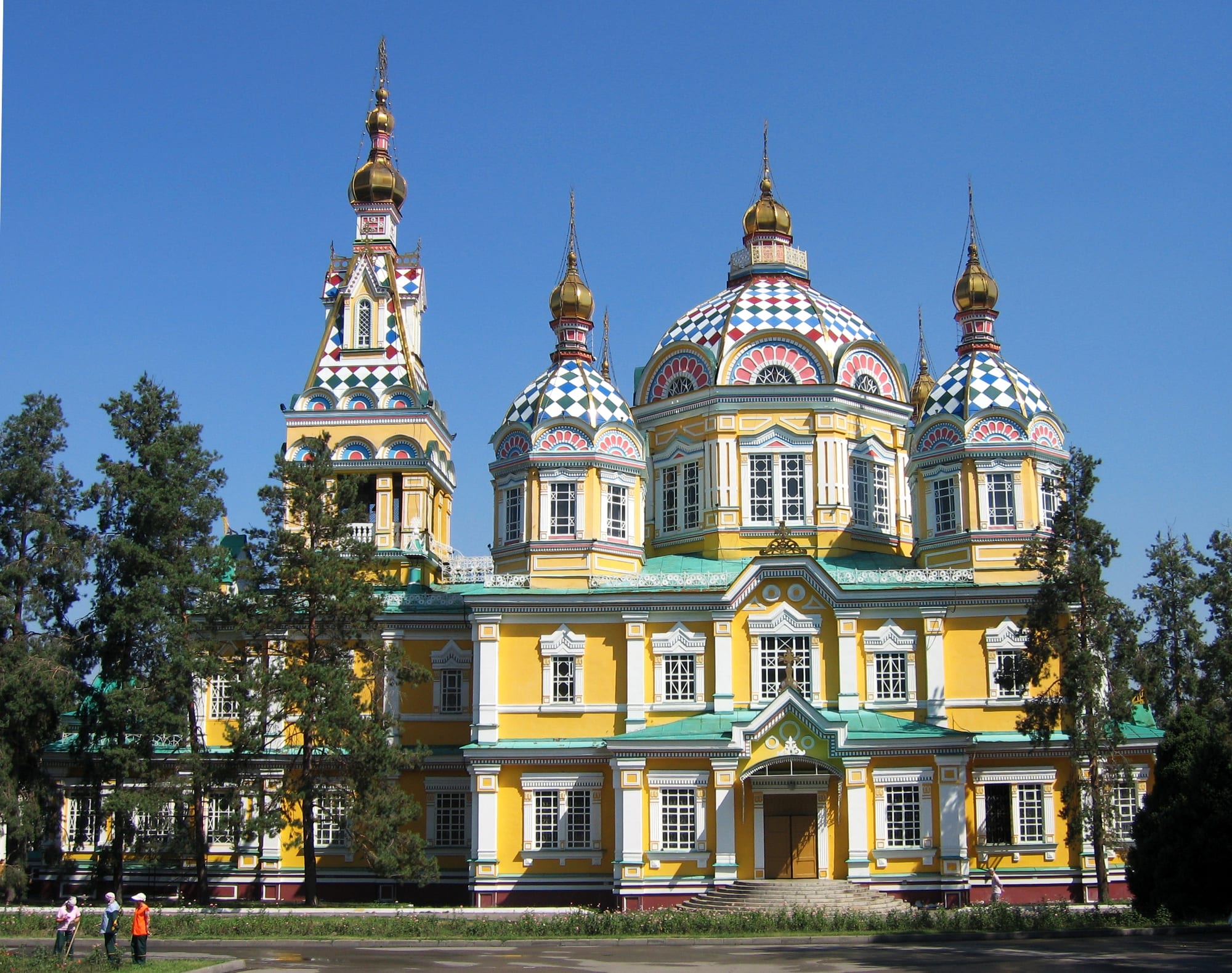 A brightly painted yellow wooden cathedral with colourful onion domes