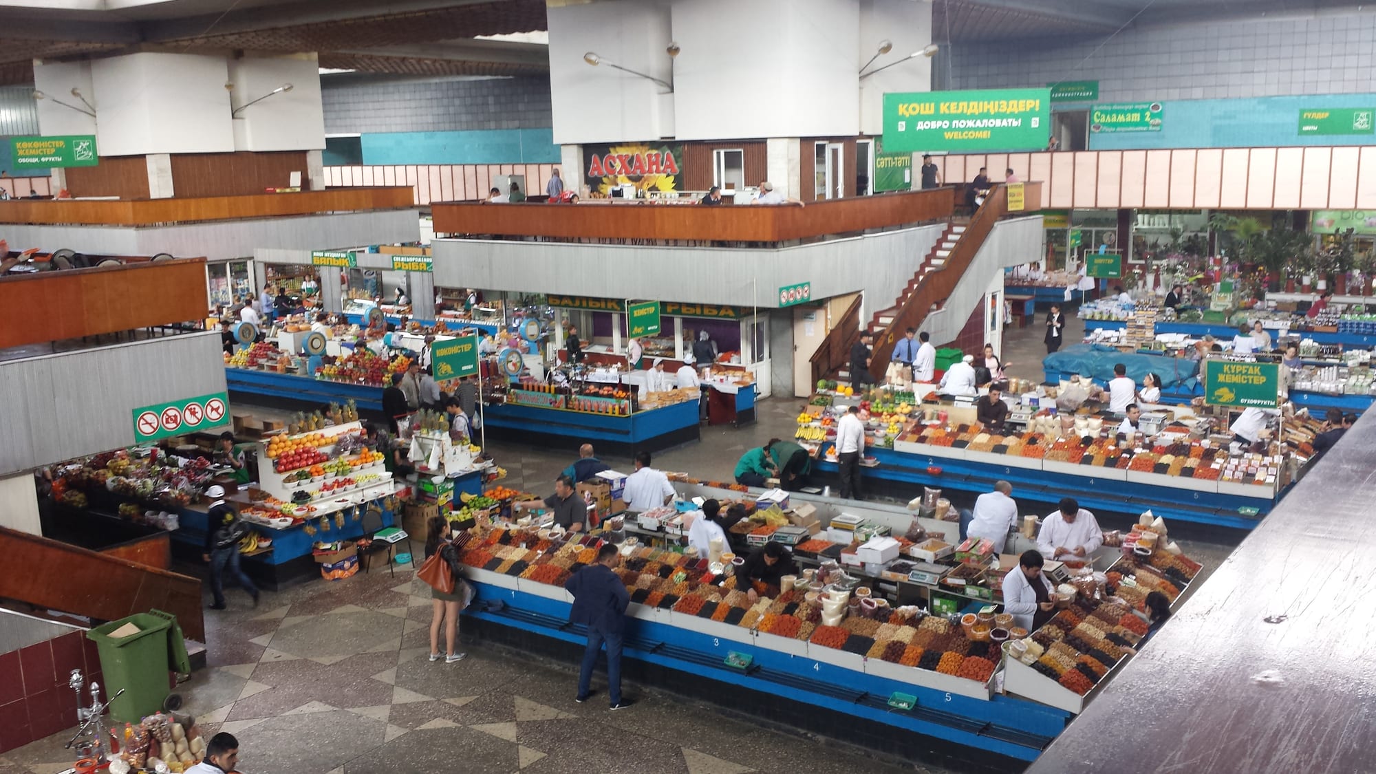 A busy indoor market hall with vendors and produce