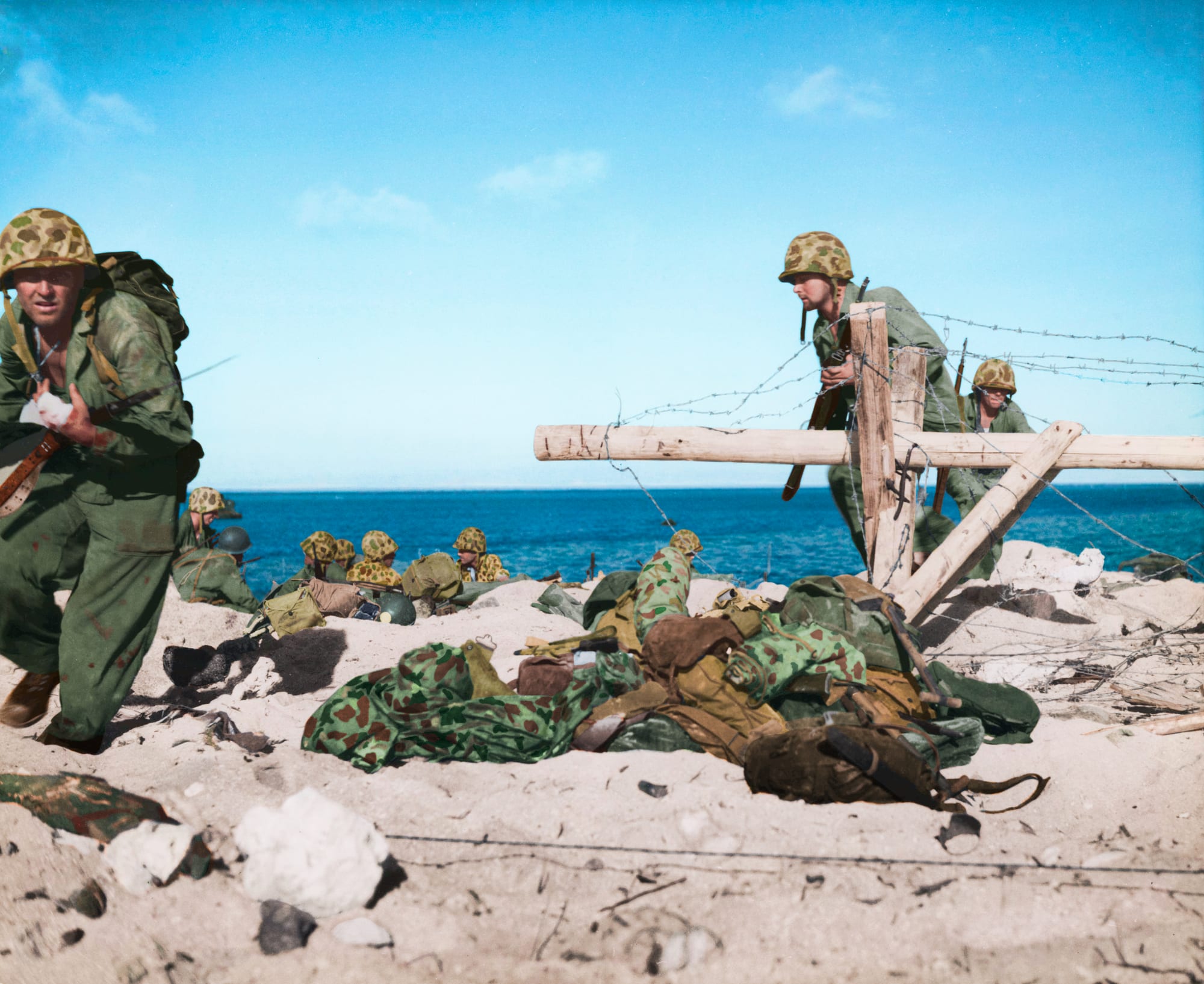 US Marines advancing among wreckage and palm stumps on Betio island, 1943