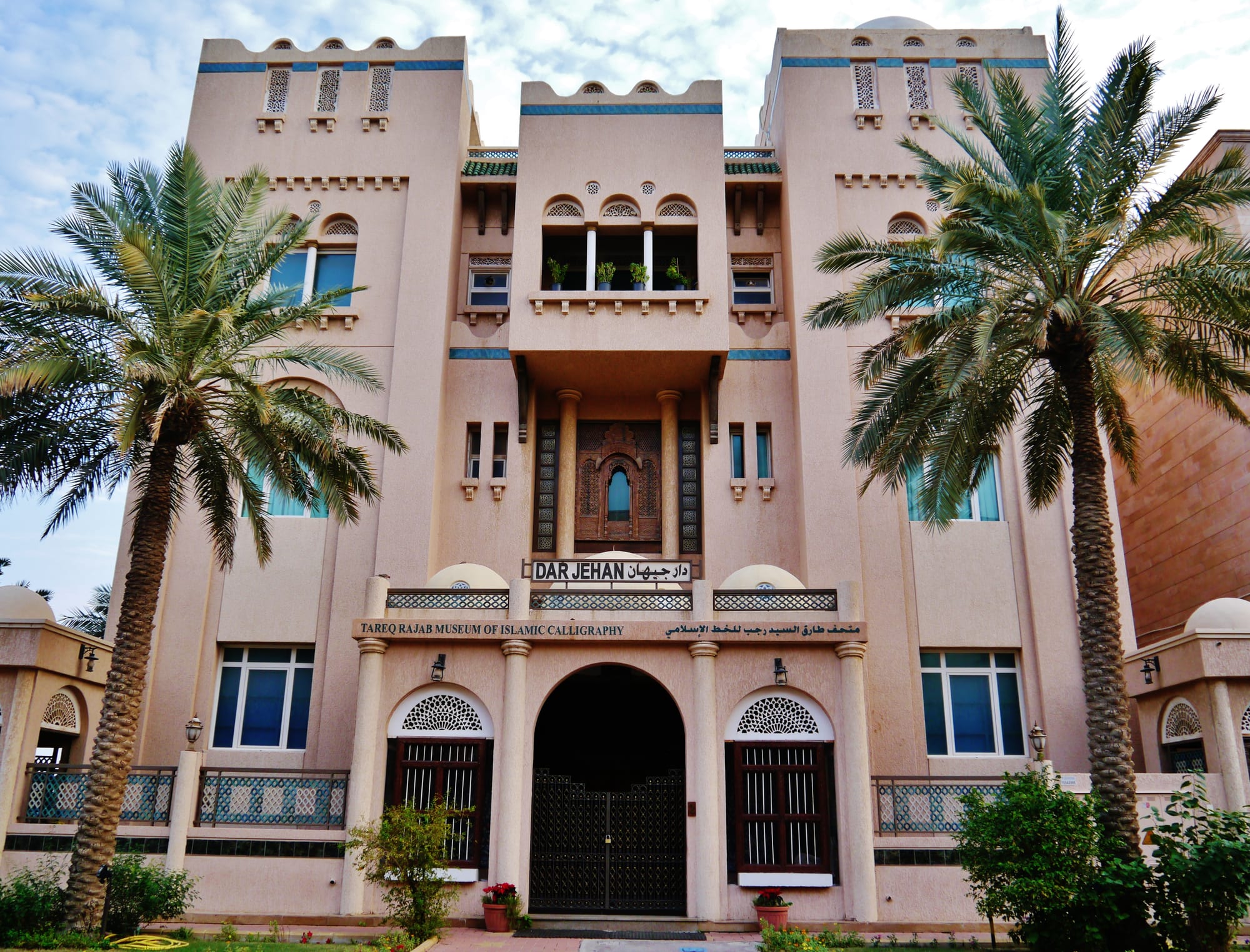 A dimly lit museum gallery displaying framed Islamic calligraphy and manuscripts
