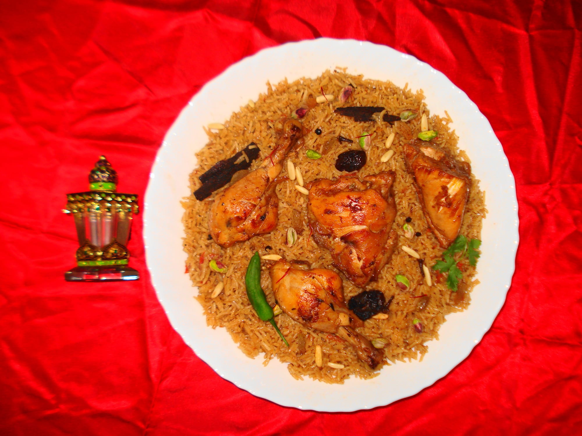 A large platter of spiced rice topped with pieces of meat