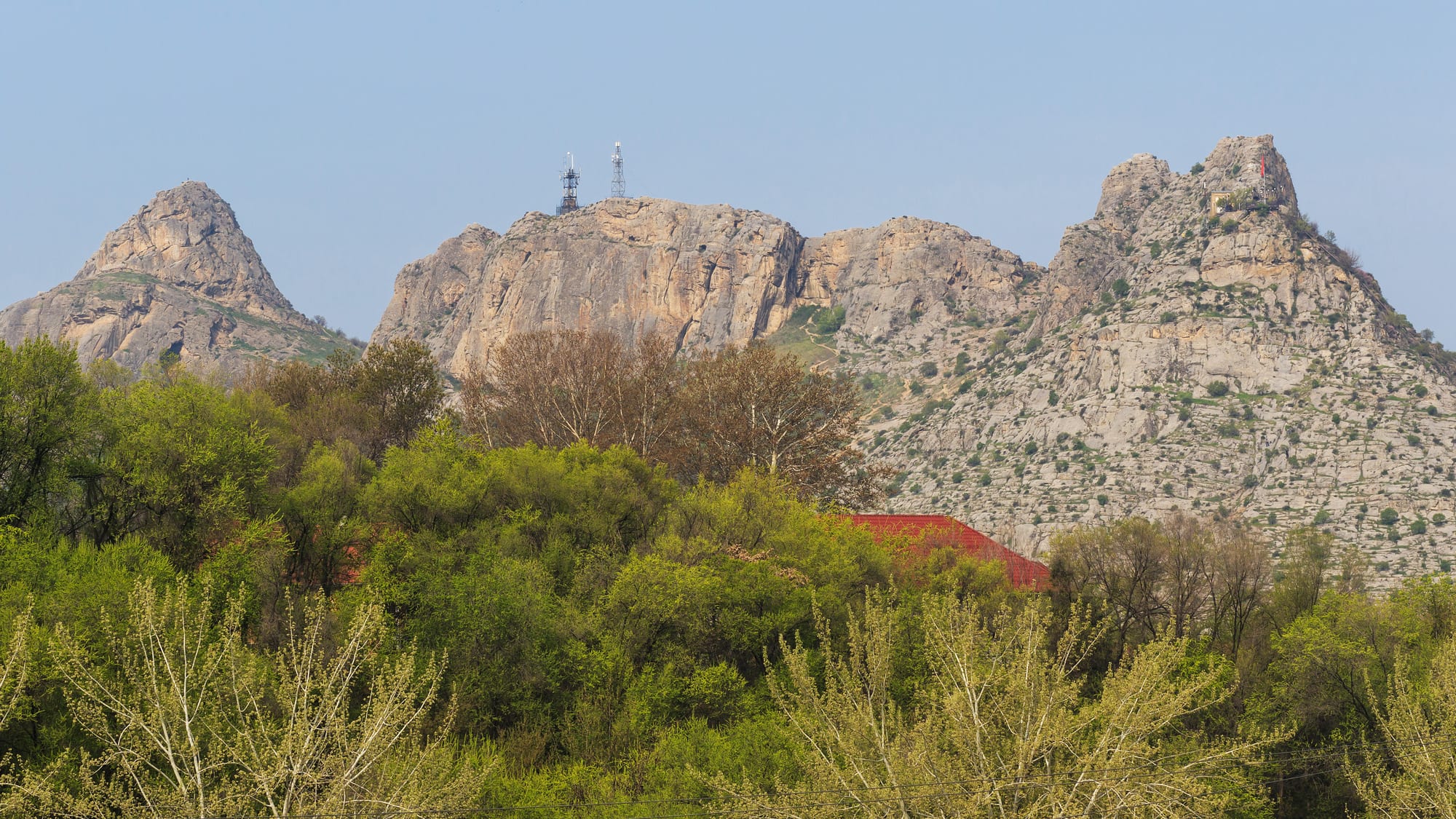 A rocky ridge rising abruptly out of a city, with a small mosque near its base