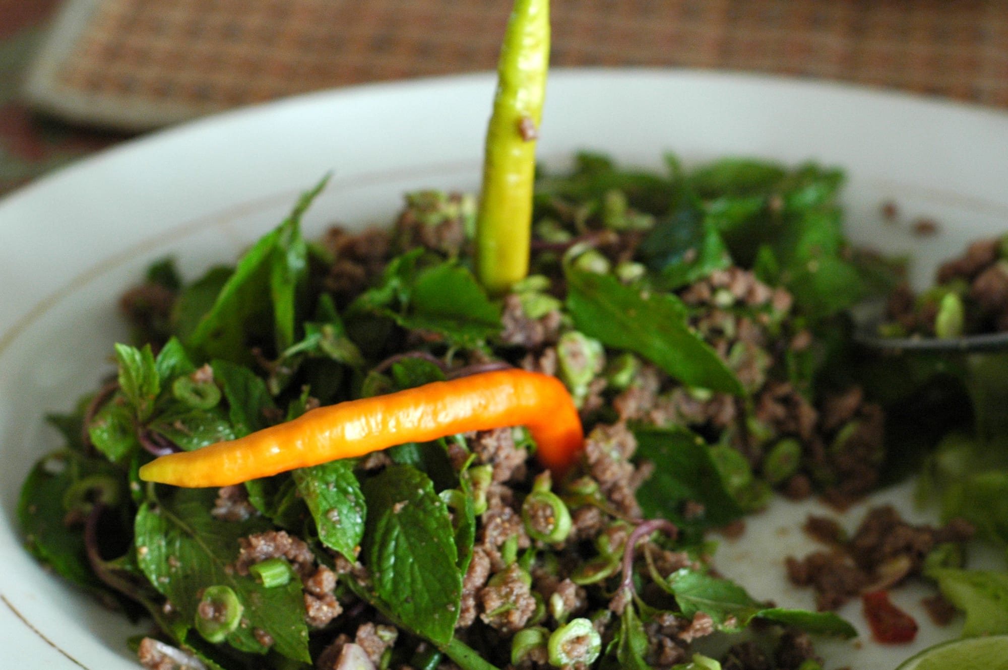 A plate of minced meat salad with herbs and lime