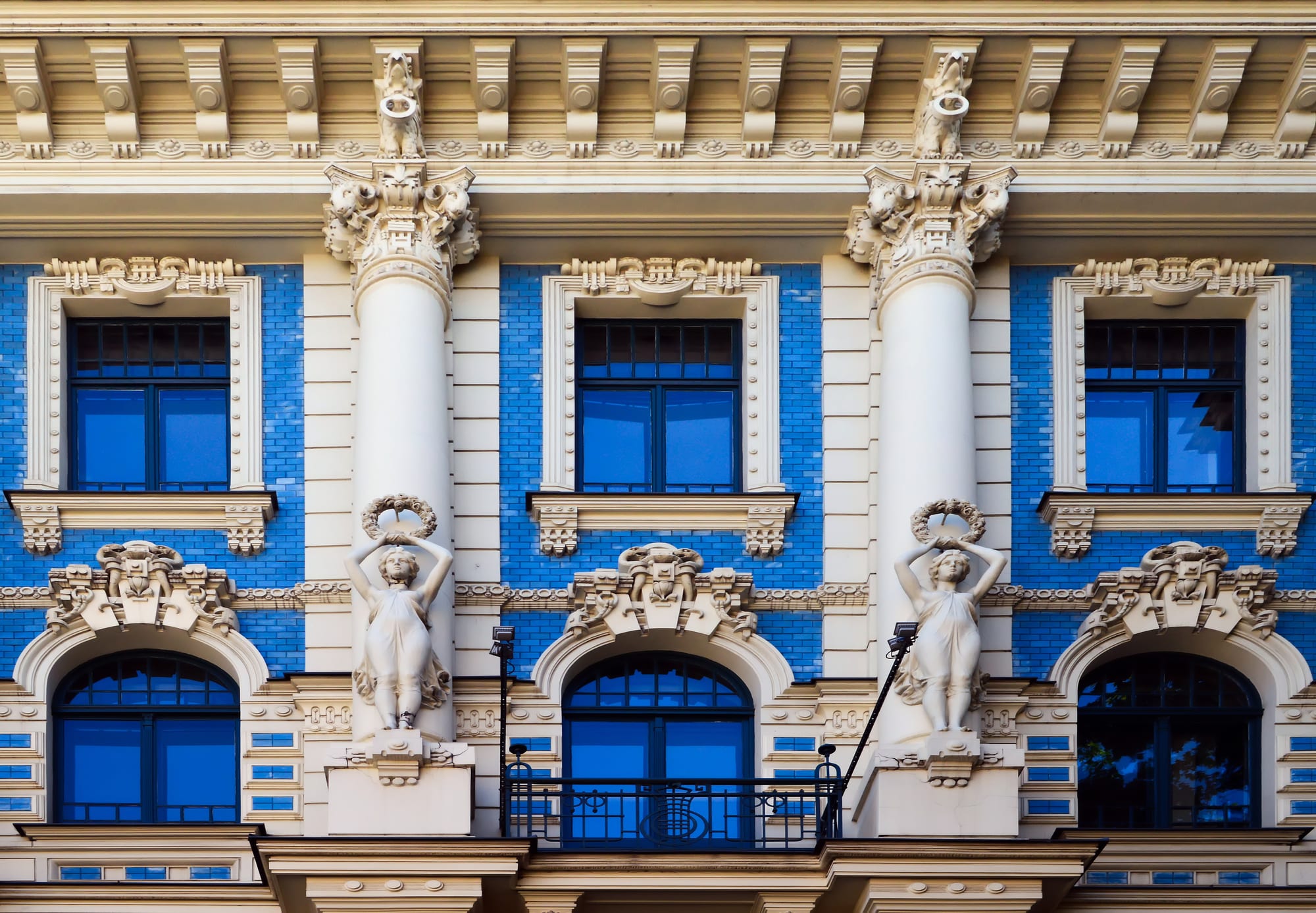 An elaborate facade covered in sculpted faces, swirling ornament, and decorative ironwork