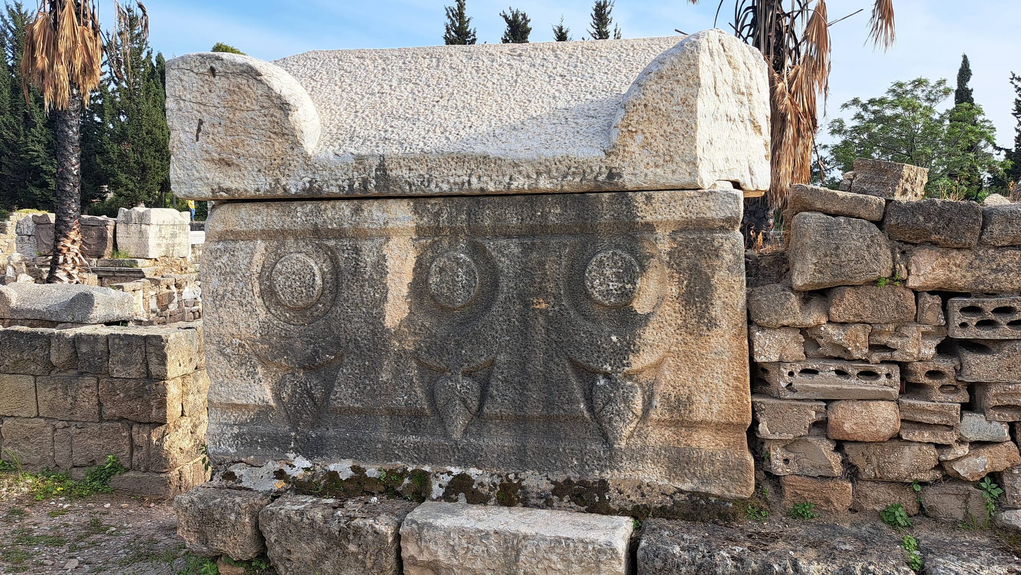 Ranks of carved stone sarcophagi lining a Roman-era necropolis avenue