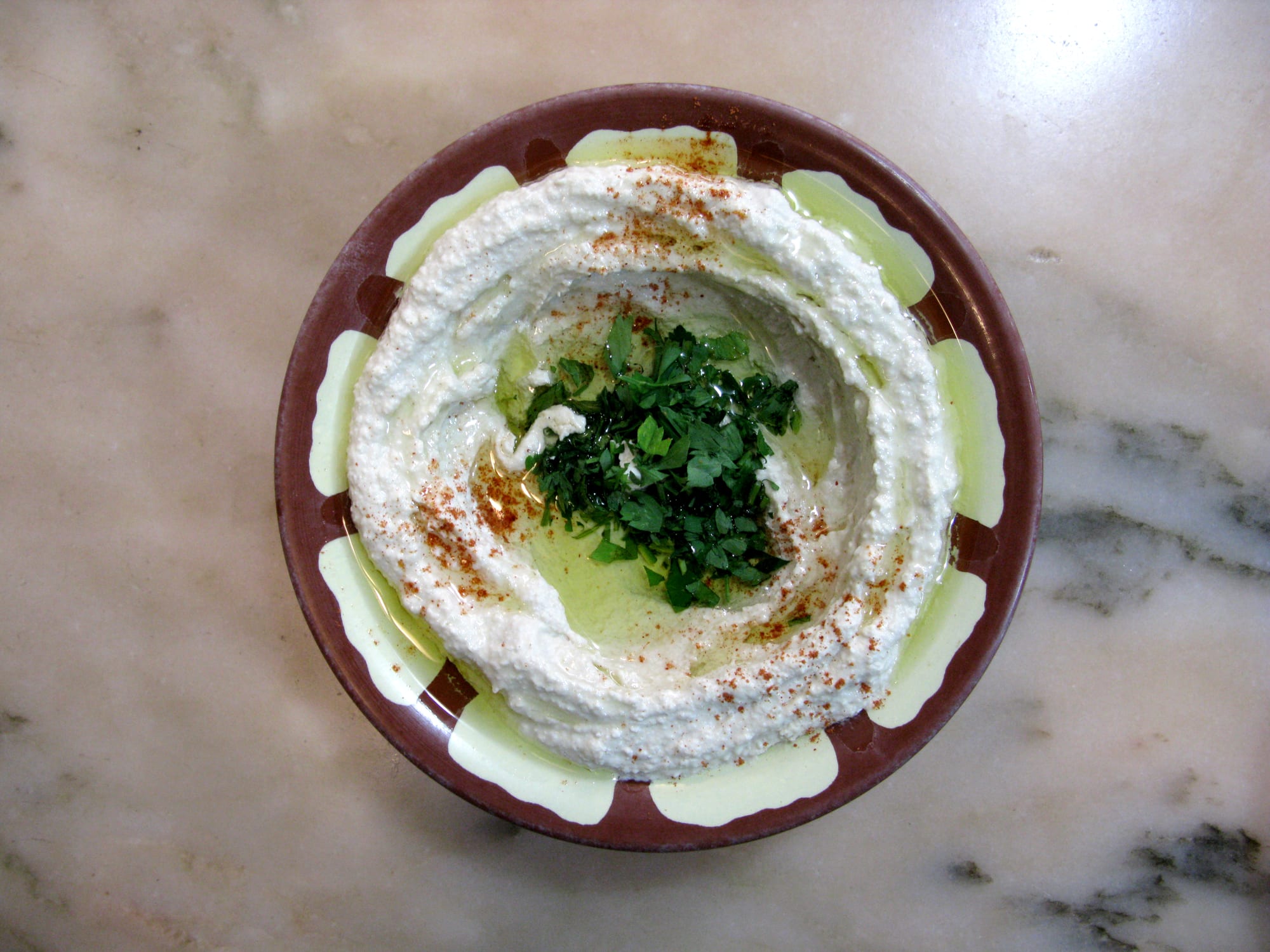A plate of hummus drizzled with olive oil