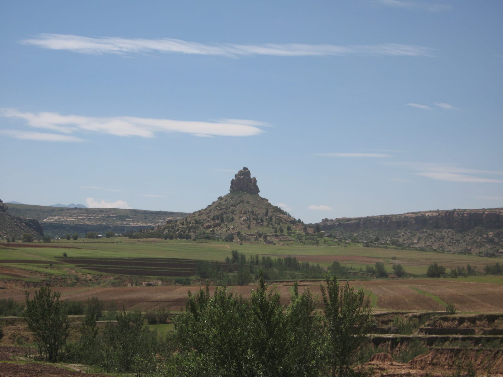 A large flat-topped sandstone mountain rising from a plain, seen from a distance