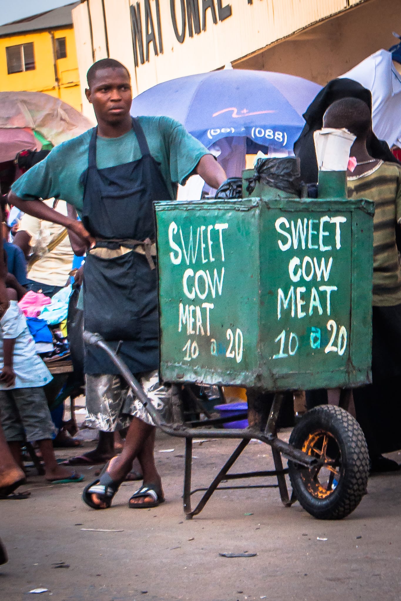 A street vendor selling meat at an outdoor market