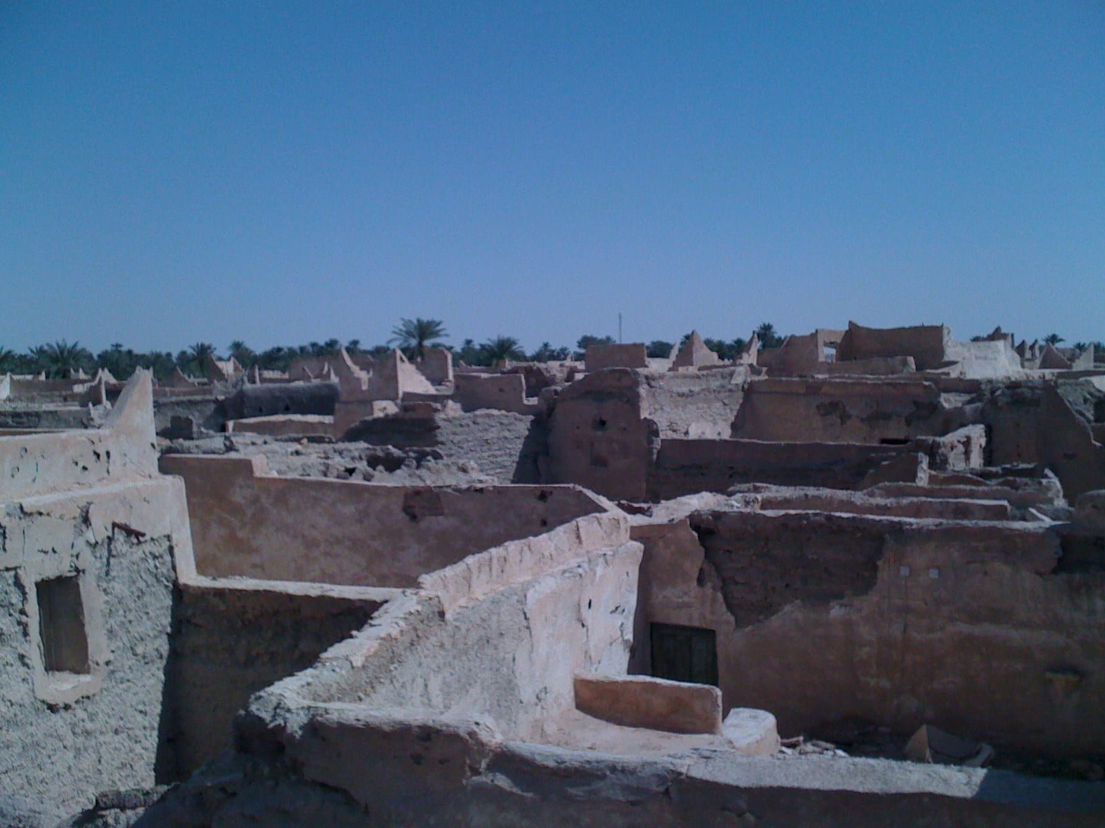 A dense cluster of whitewashed mud-brick houses and covered lanes, rooftop terraces above