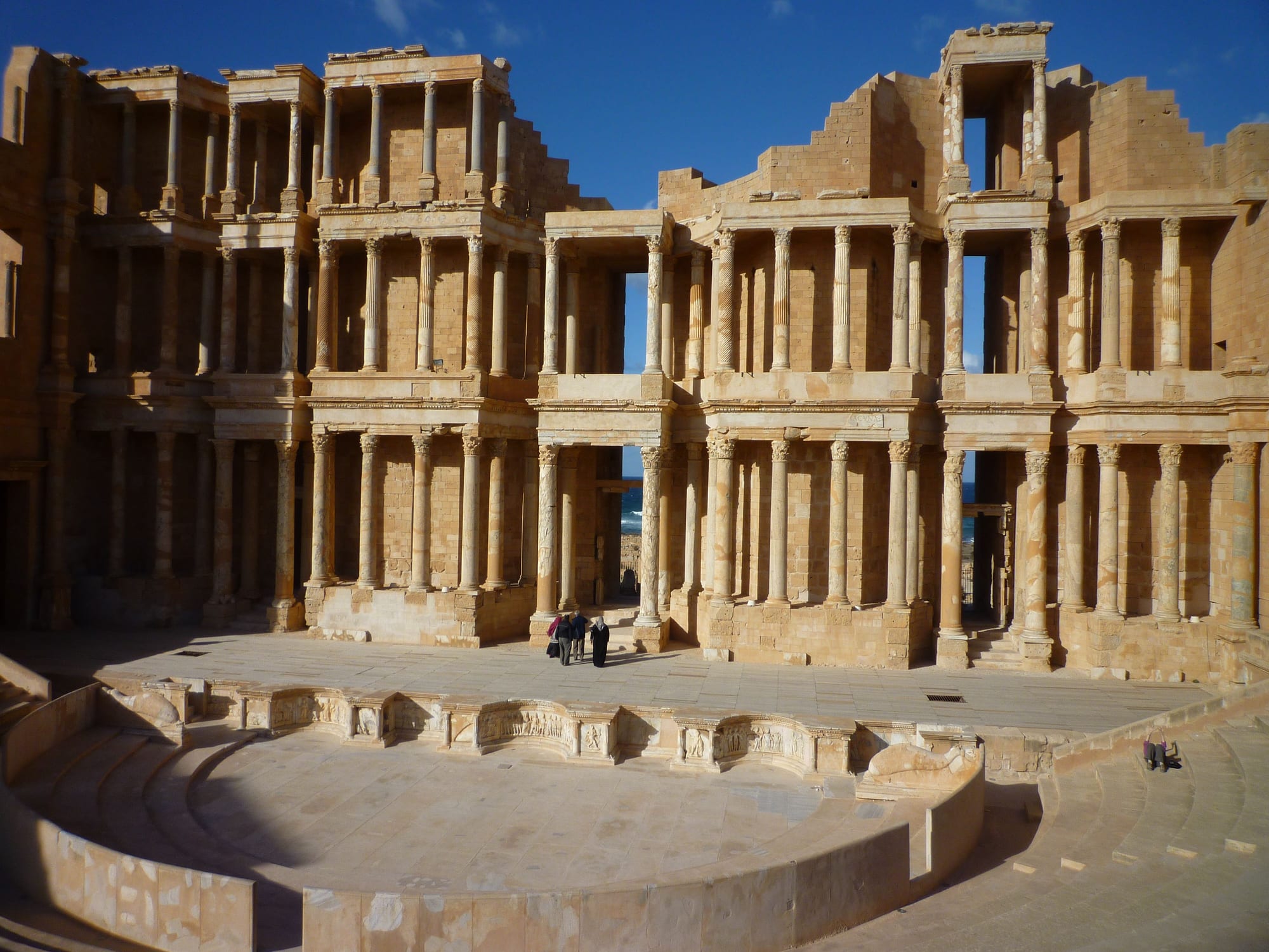 A tall, three-tiered Roman theatre stage backdrop of columns, right on the seashore