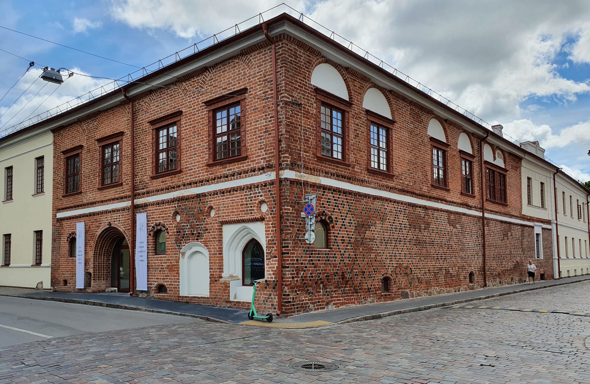 A white gabled palace building beside a cobbled town square