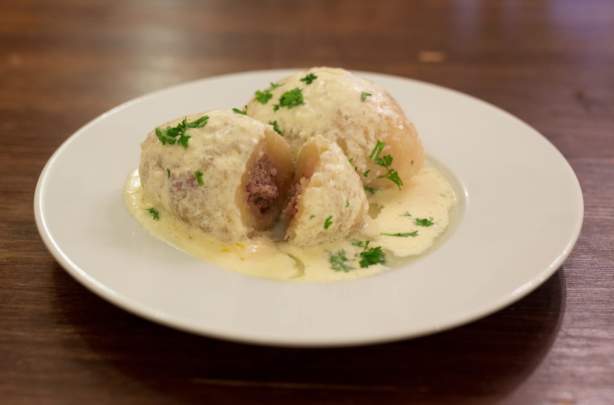 Large oval potato dumplings covered in a cream sauce with bacon
