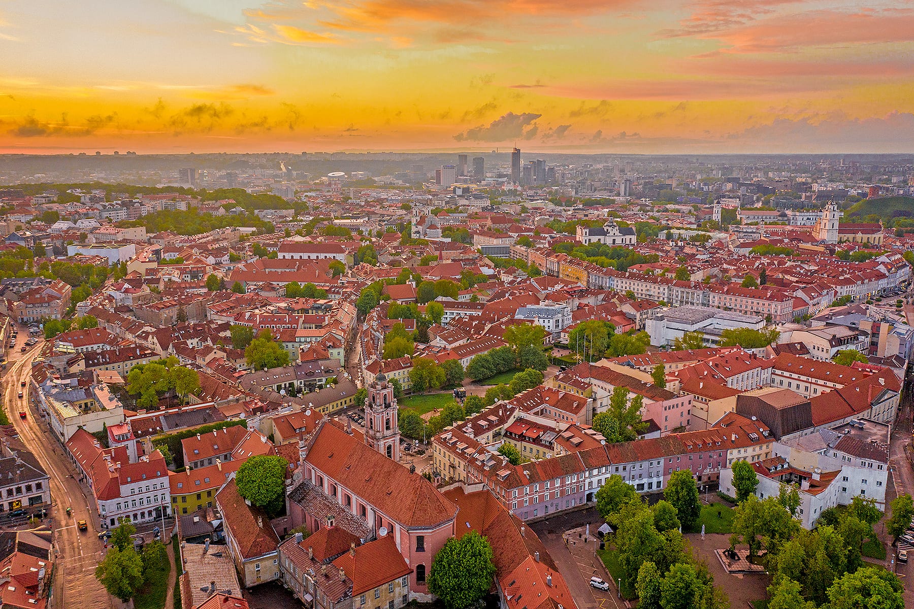 A skyline of baroque church towers and red rooftops across the old town of Vilnius