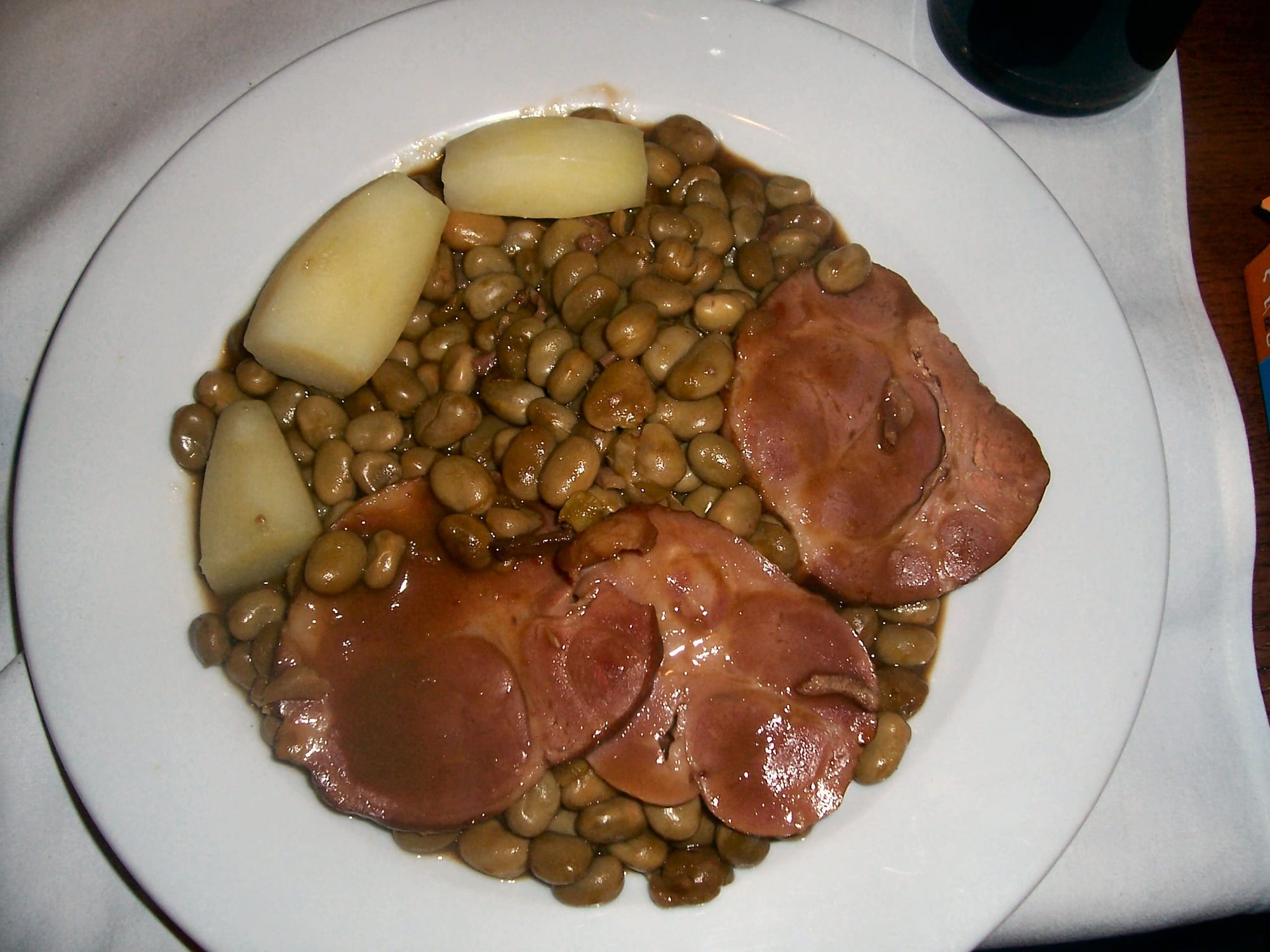 Sliced smoked pork served with broad beans and potatoes