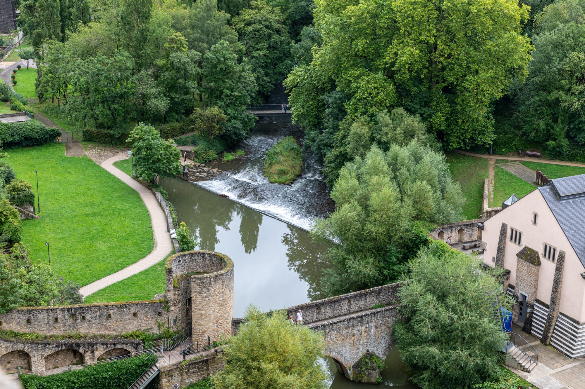 An old town on high cliffs above a deep green river gorge, with fortified walls and bridges