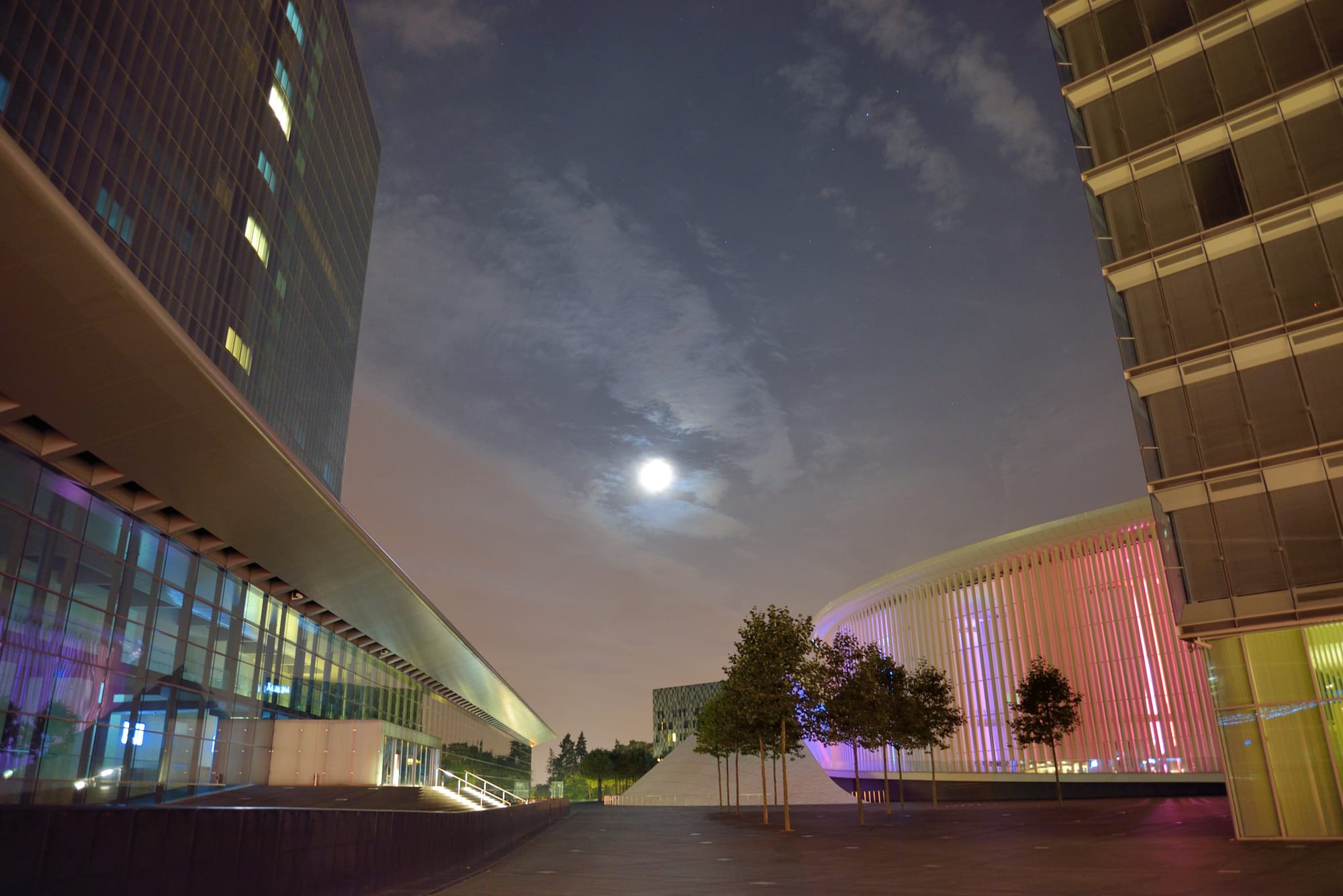 Floodlit modern towers and the Philharmonie concert hall around Place de l'Europe on the Kirchberg plateau at night