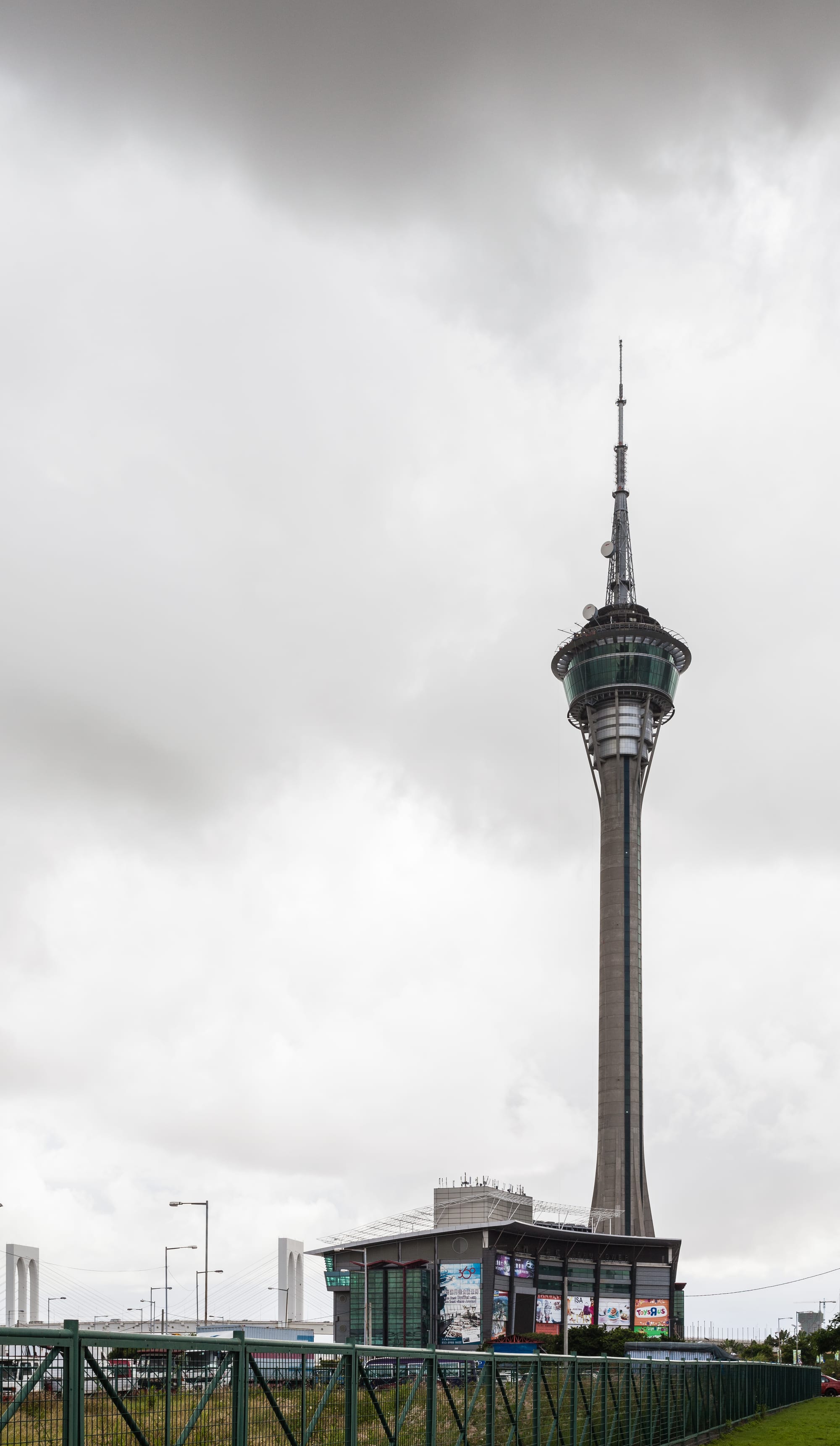 A tall, slender observation tower with a bulb-shaped top rising above the city