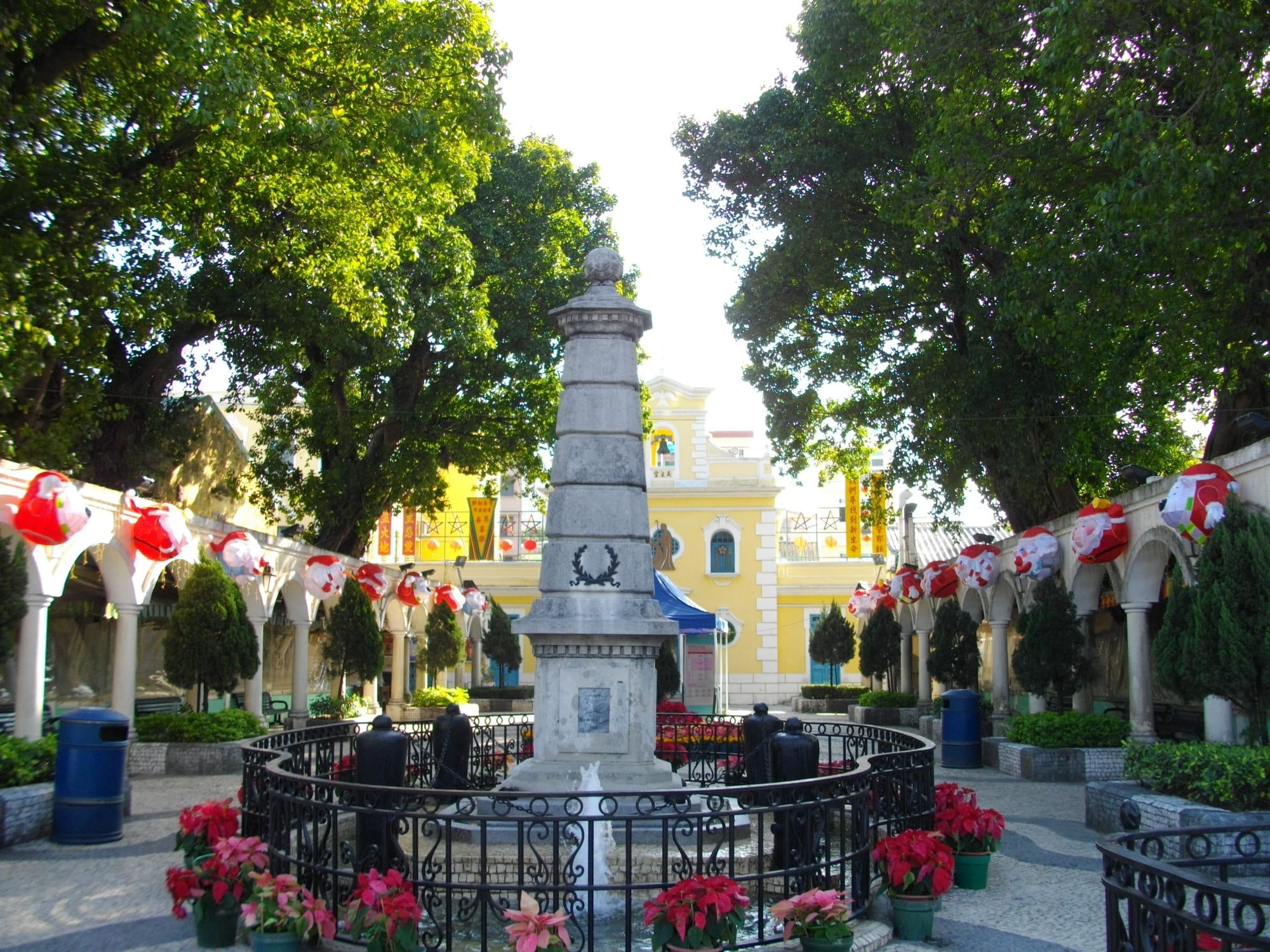A quiet pastel-coloured colonial village square with a small chapel