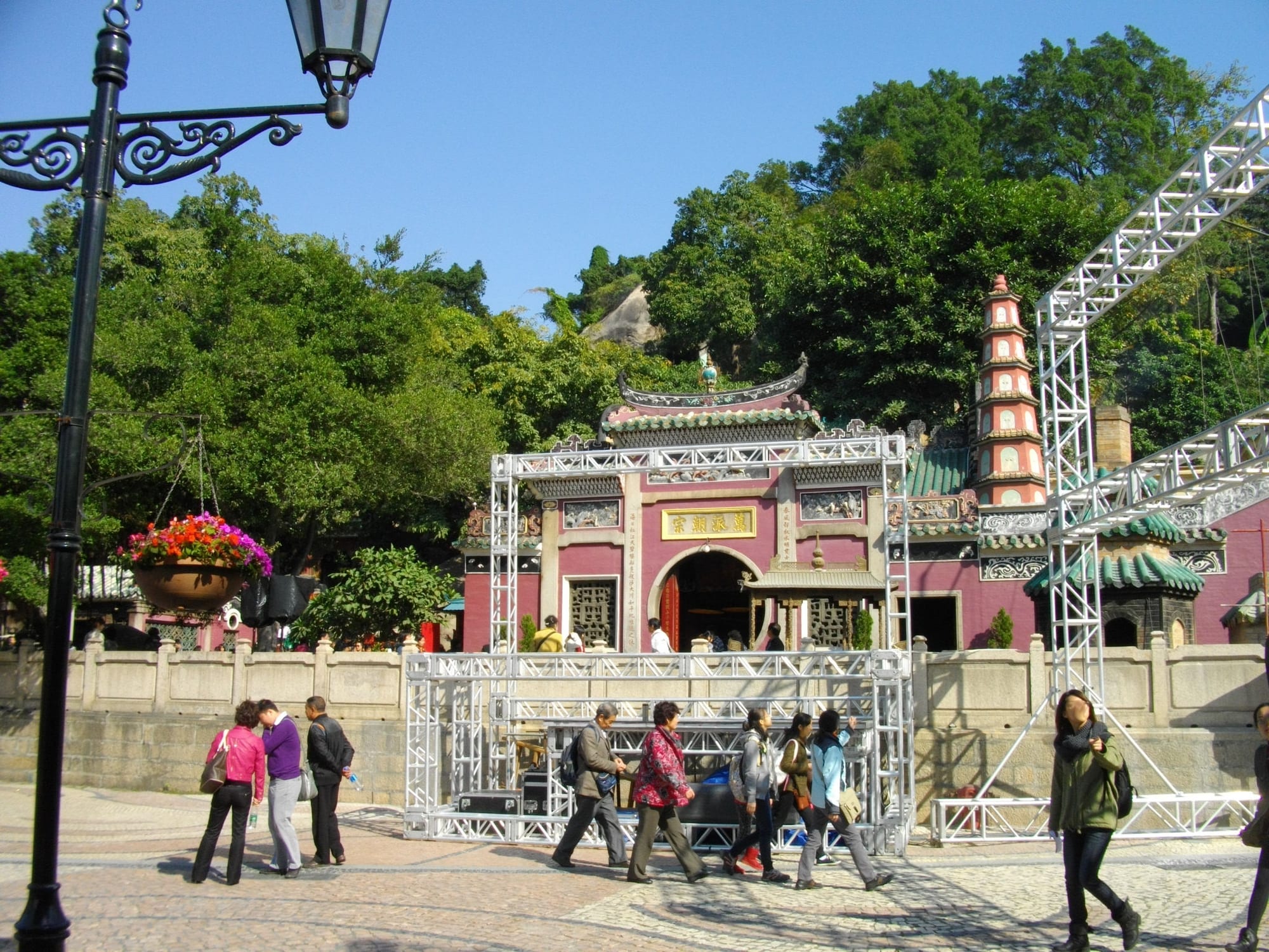 A traditional Chinese temple complex built into a rocky hillside, incense smoke rising