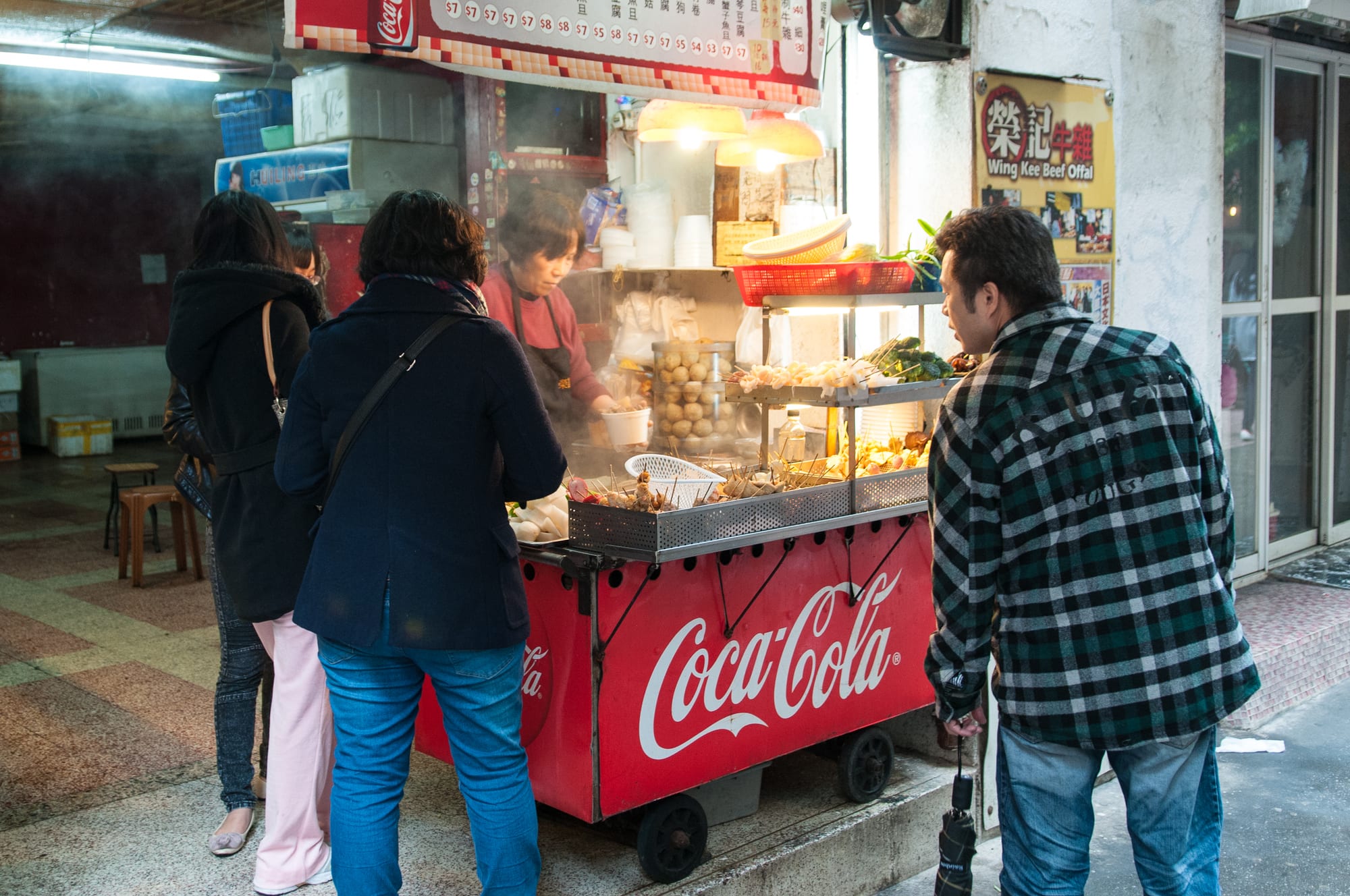 A street food stall with vendors and food on display