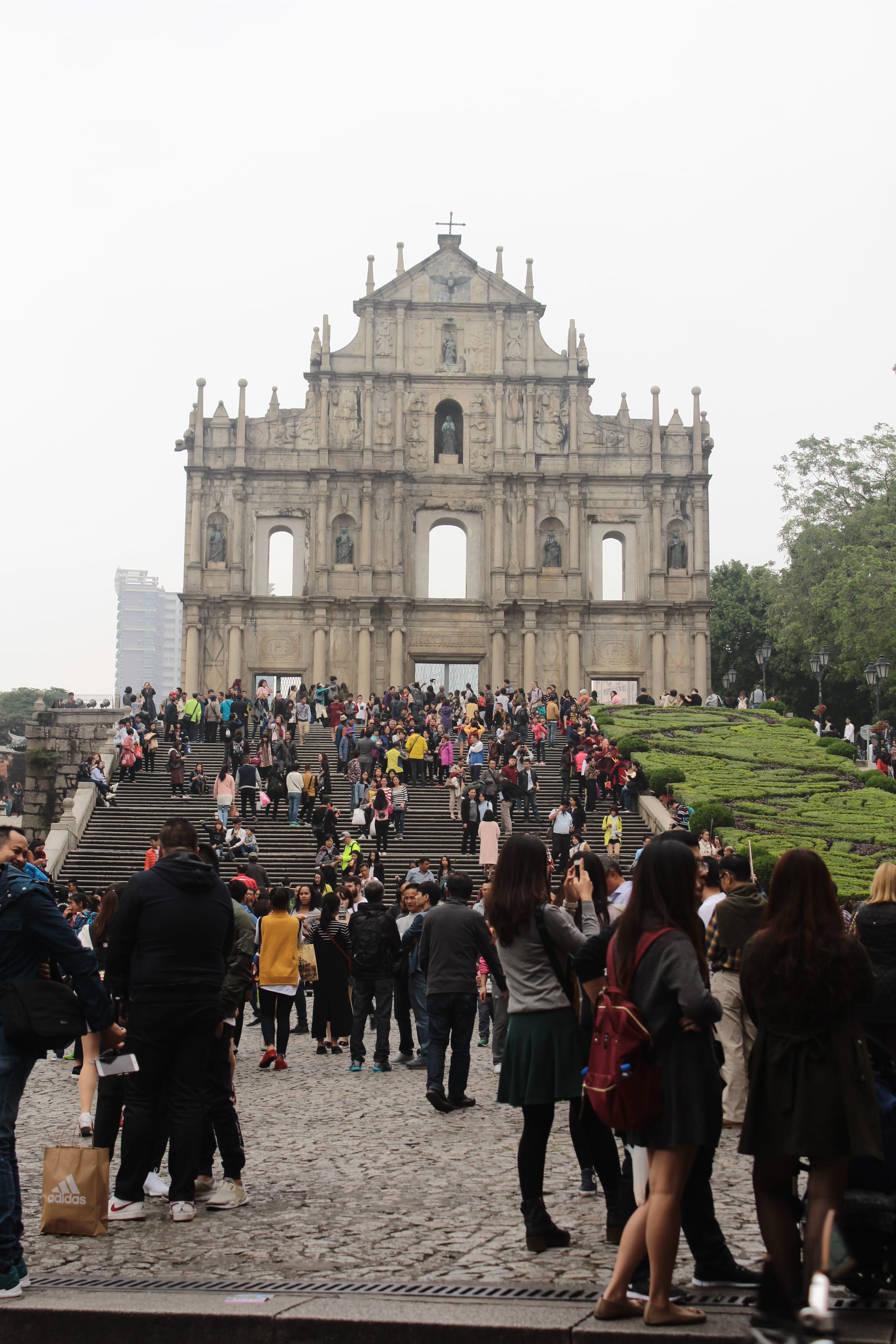 An ornate stone church facade standing alone at the top of a grand staircase, with nothing behind it