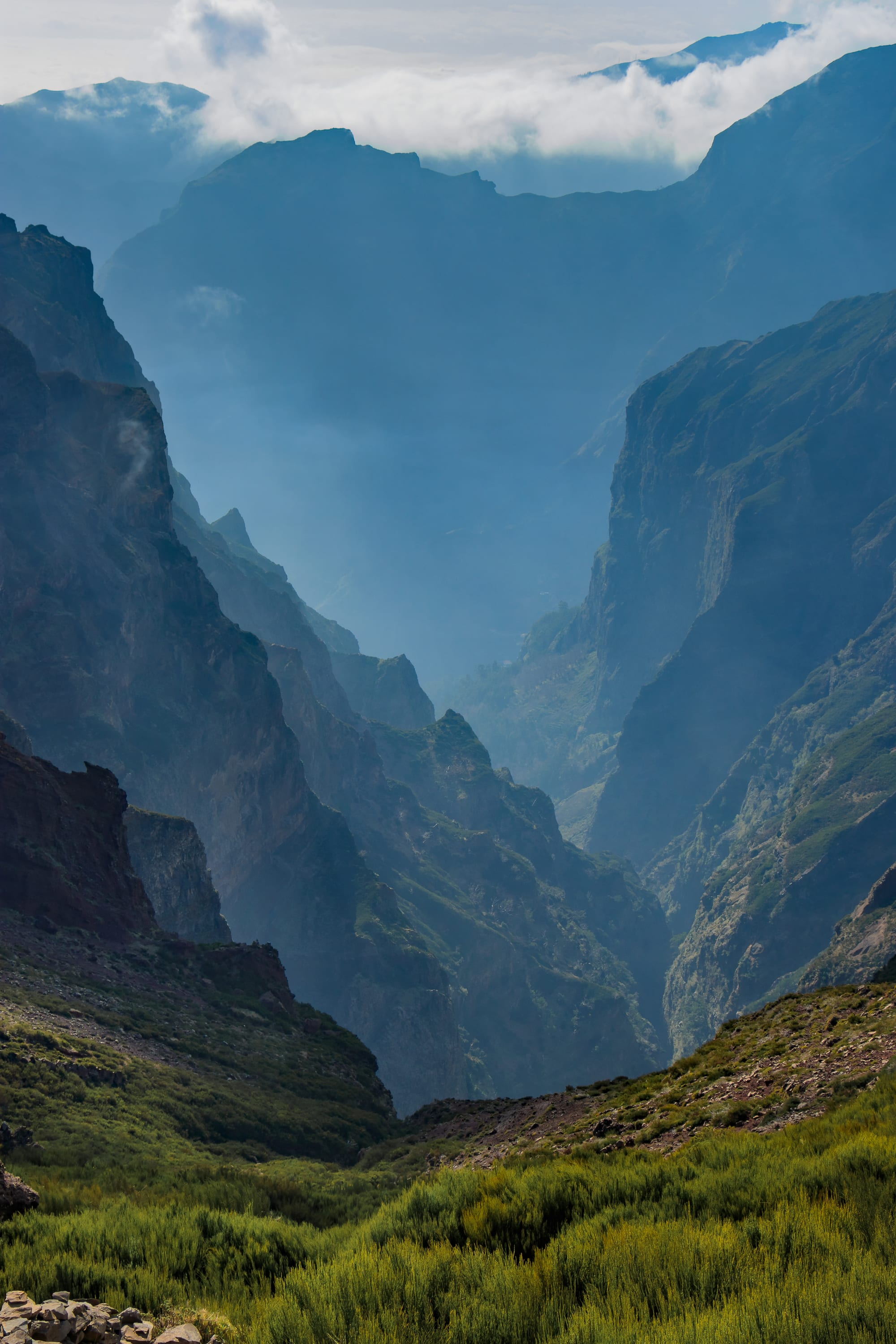 Jagged volcanic mountain ridges rising above a sea of cloud
