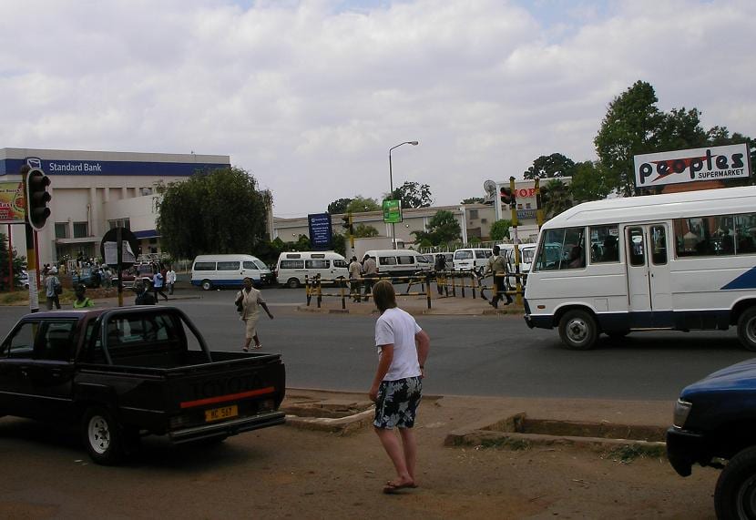 A modern low-rise city street with shops and traffic