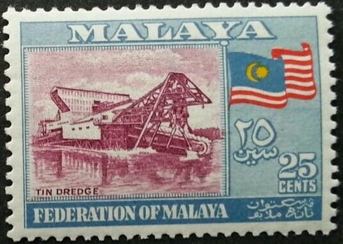 A postage stamp depicting a large floating tin dredge on a Malayan mining pond