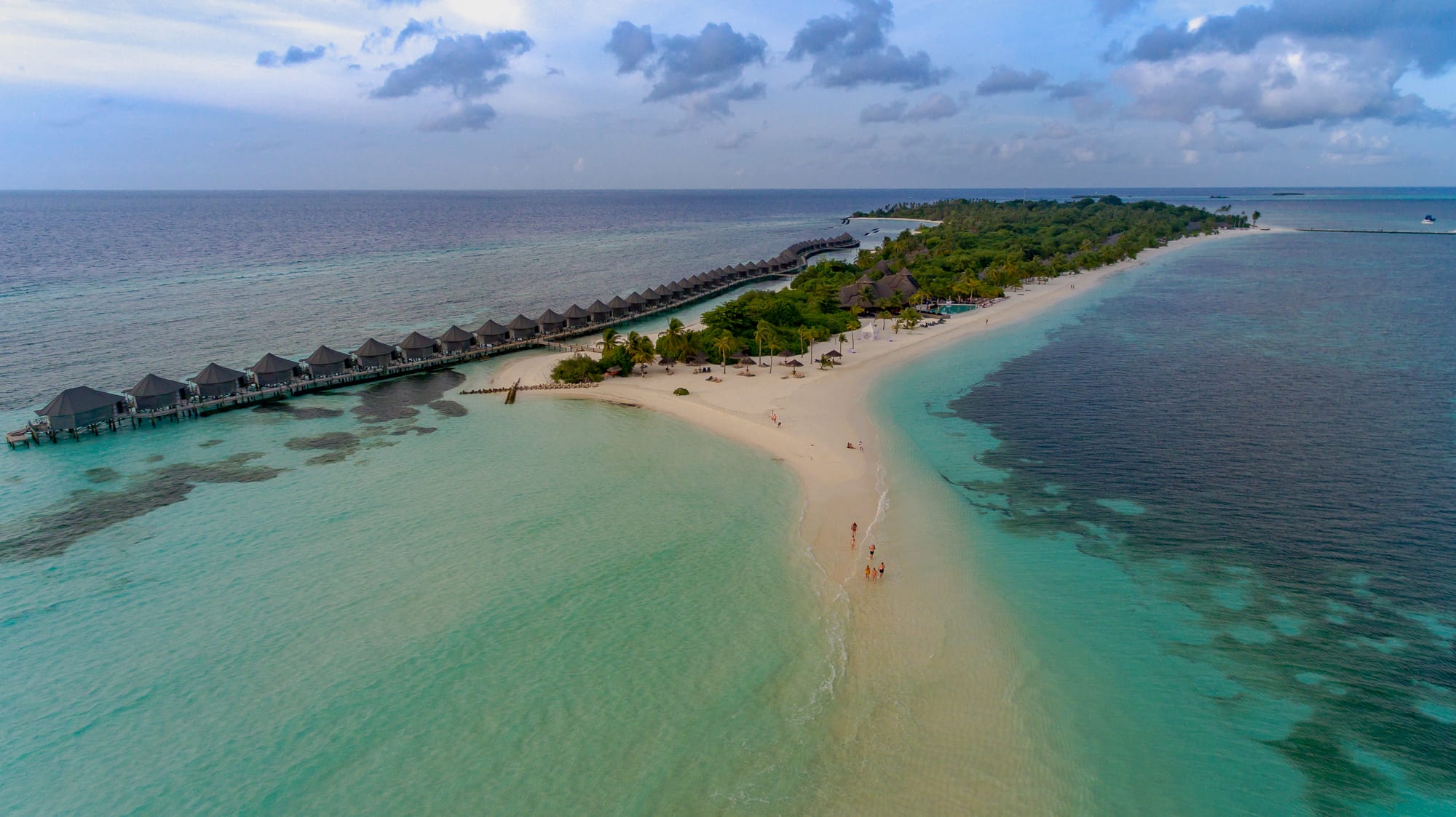 A narrow strip of pure white sand surrounded entirely by shallow turquoise water