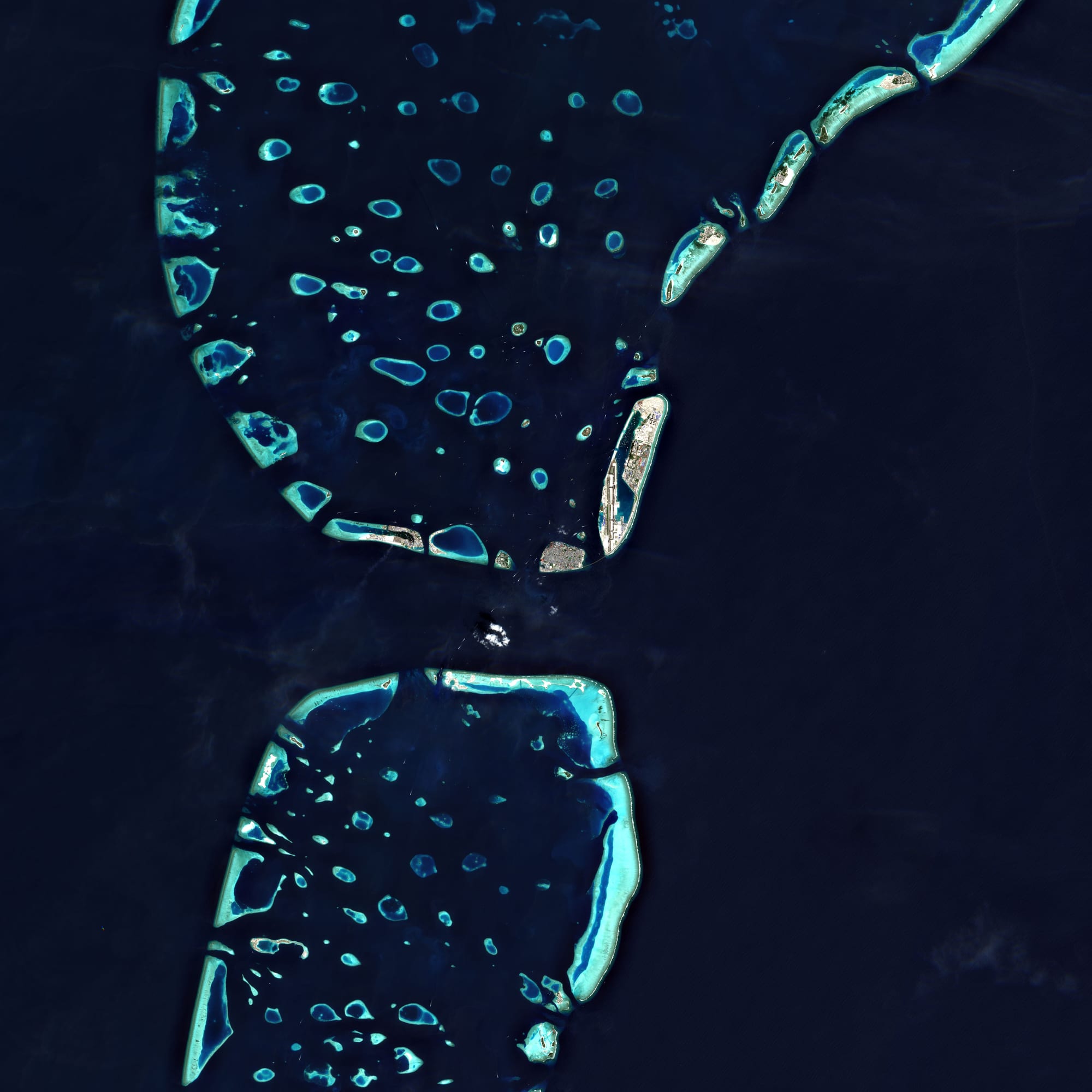 A satellite view of the crowded island of Malé beside the airport island and the reclaimed island of Hulhumalé