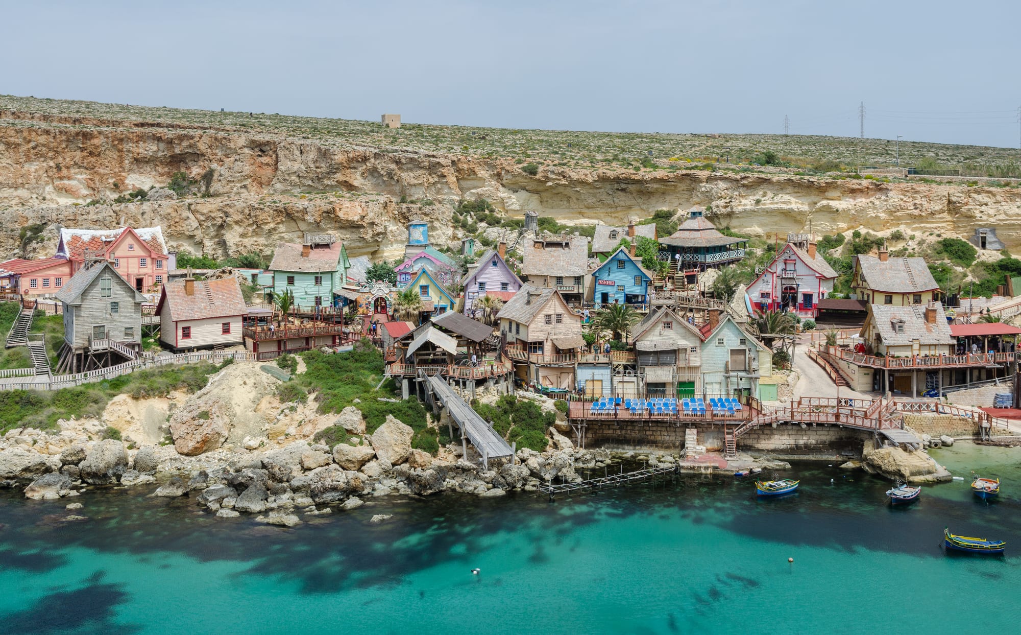 A cluster of colourful wooden fishing-village houses on stilts in a small bay