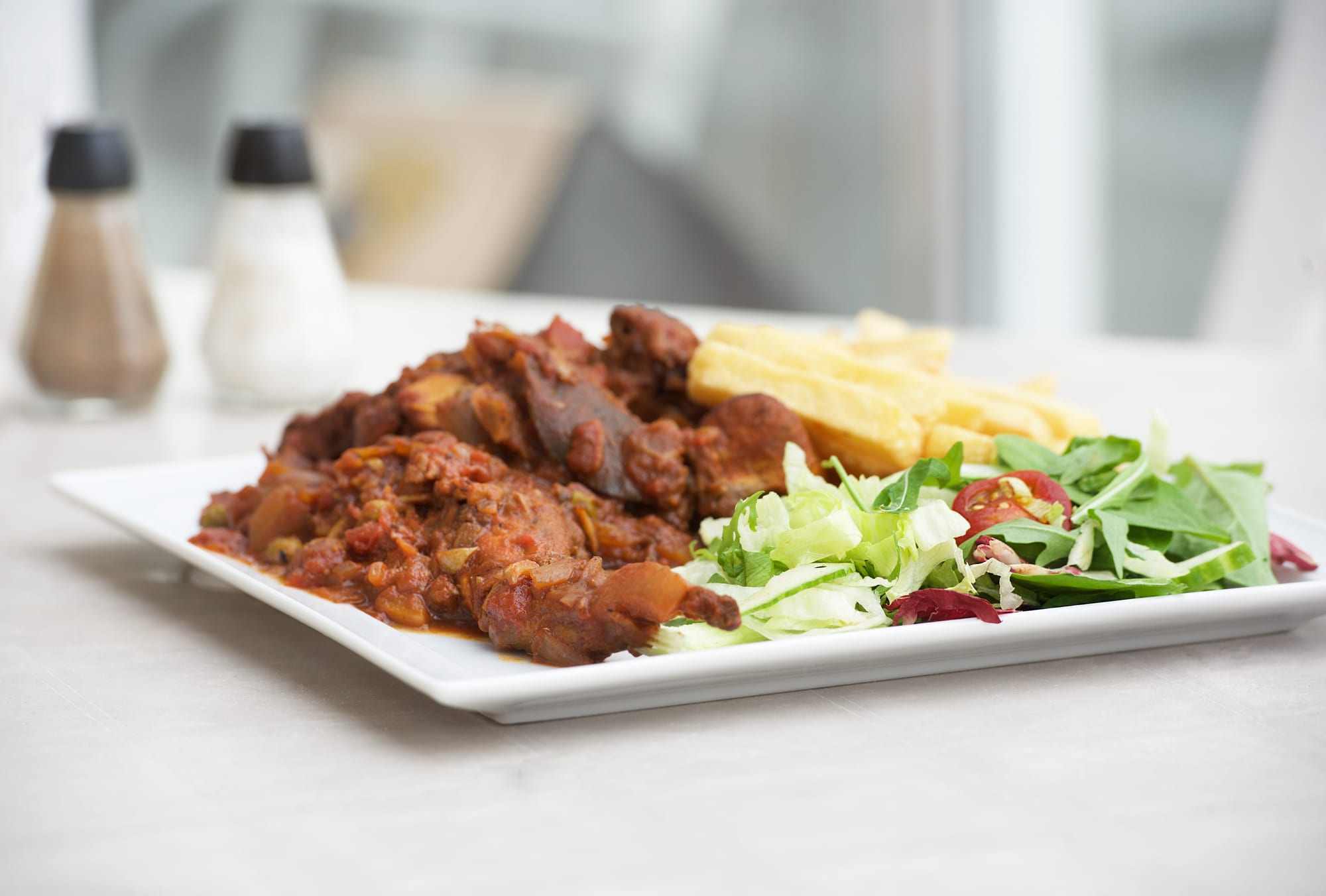 A bowl of rabbit stew in a rich red wine sauce