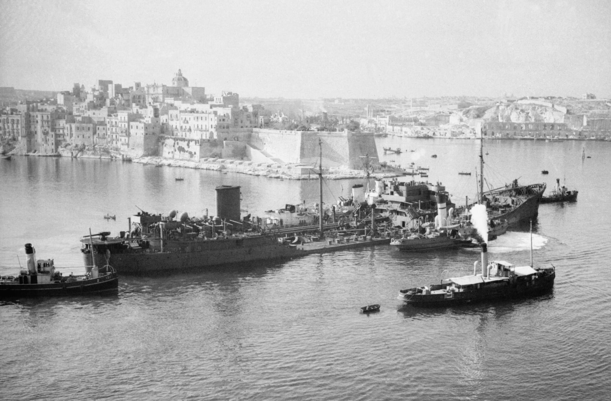 A merchant ship of the Malta convoy under way, with the coast in the distance, August 1942