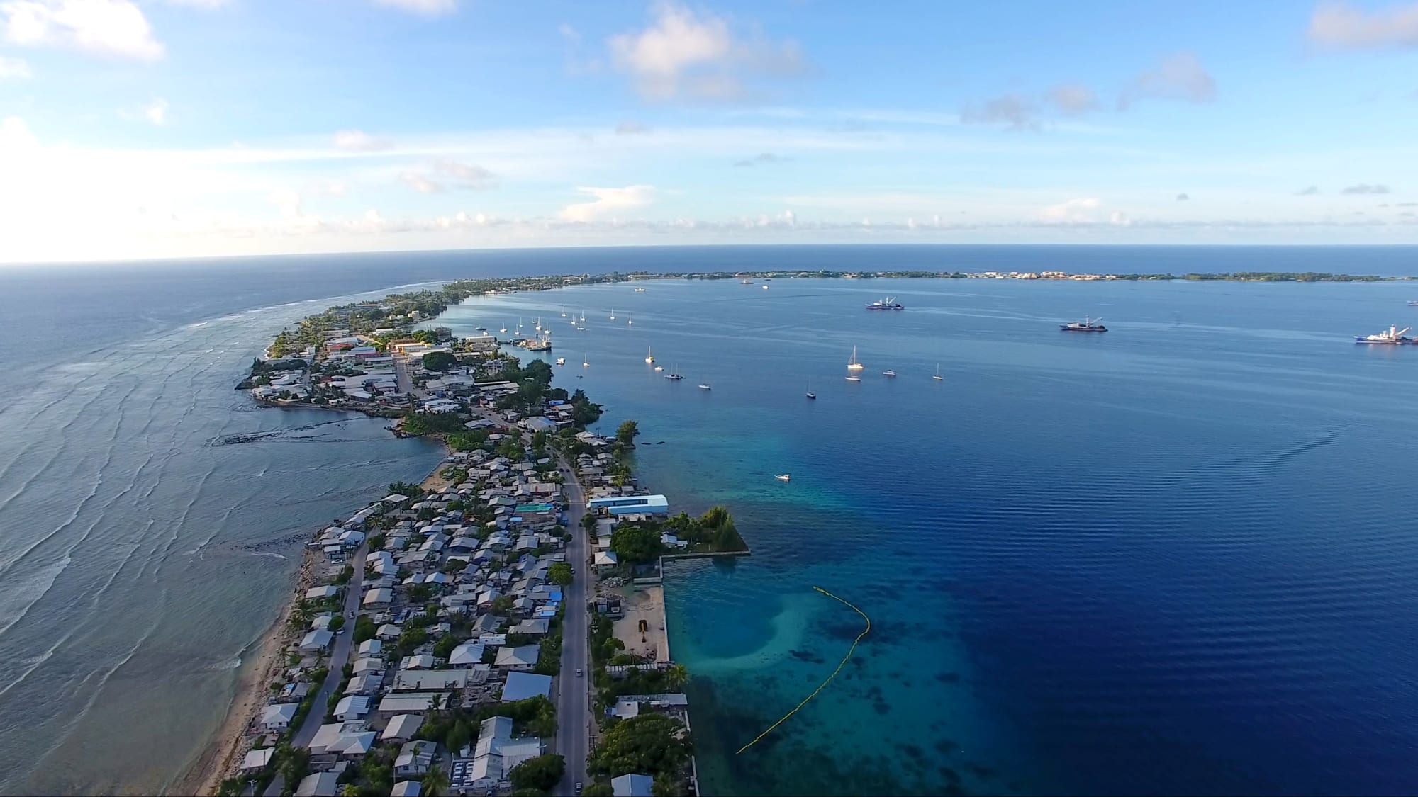 A thin ring of green land and reef enclosing a vast turquoise lagoon
