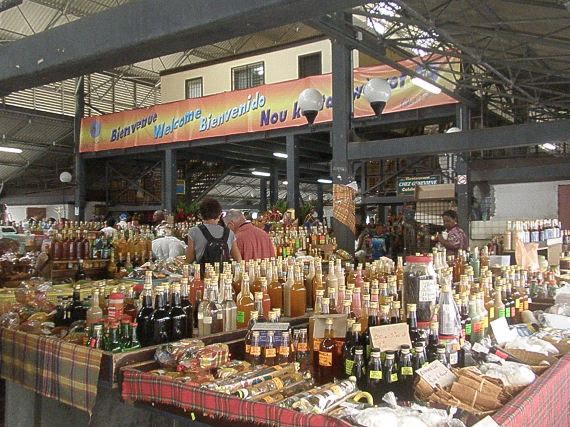 A market stall displaying bottles of rum, punch and local products