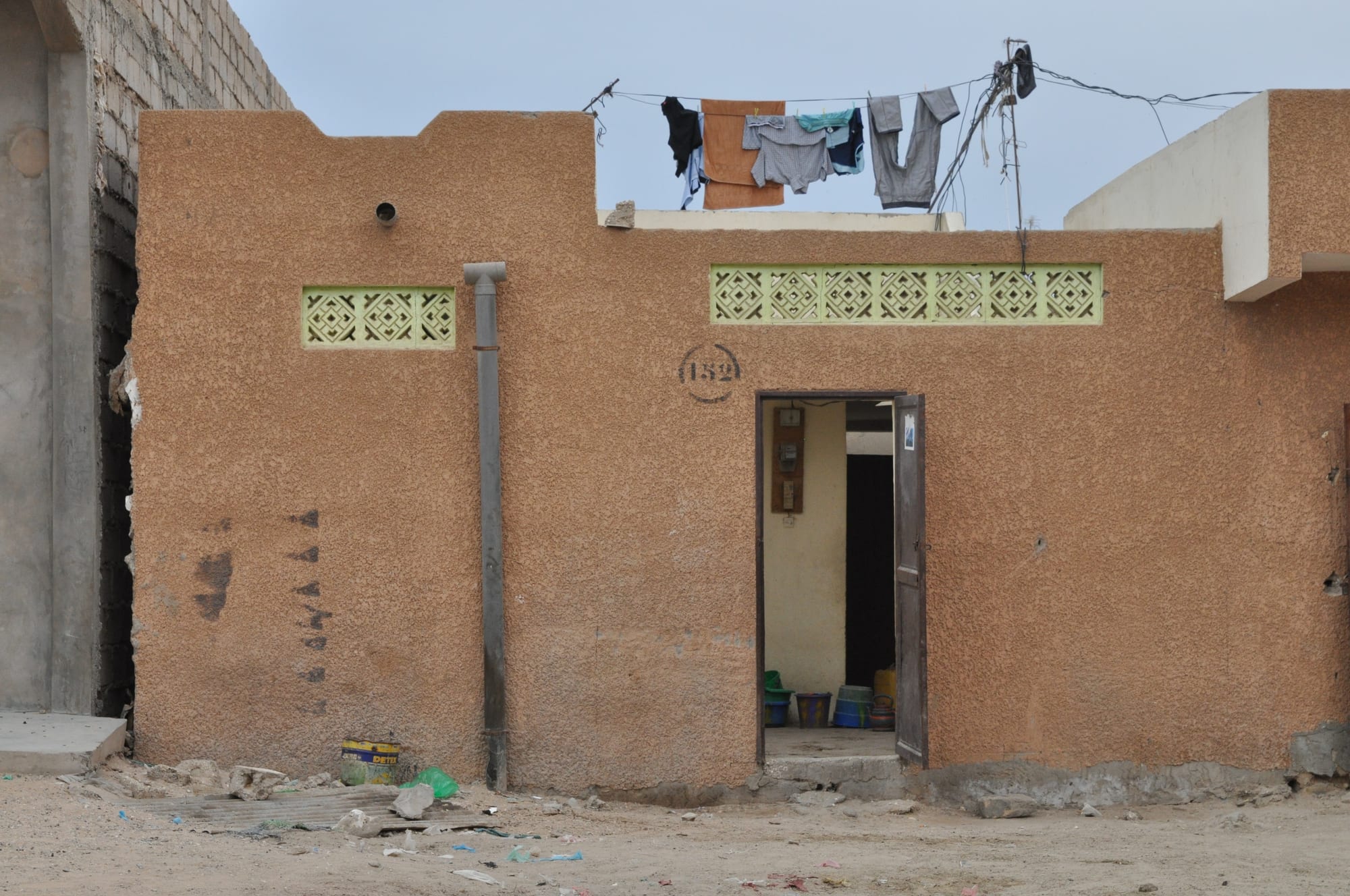 A modest single-storey house in Nouakchott with laundry hanging to dry on the flat roof